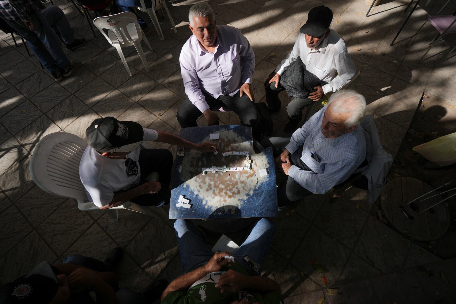 Retired people play dominoes at Obregon square in Culiacan, Sinaloa state, Mexico, Thursday, Feb. 27, 2025. (AP Photo/Fernando Llano)