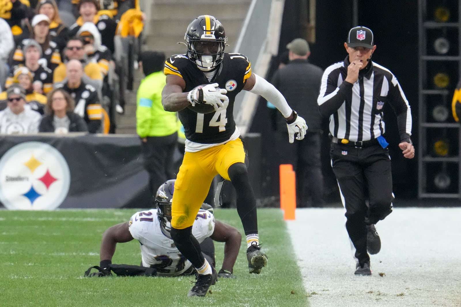 Pittsburgh Steelers wide receiver George Pickens (14) avoids a tackle by Baltimore Ravens cornerback Brandon Stephens (21) during the second half of an NFL football game, Sunday, Nov. 17, 2024, in Pittsburgh. (AP Photo/Gene J. Puskar)