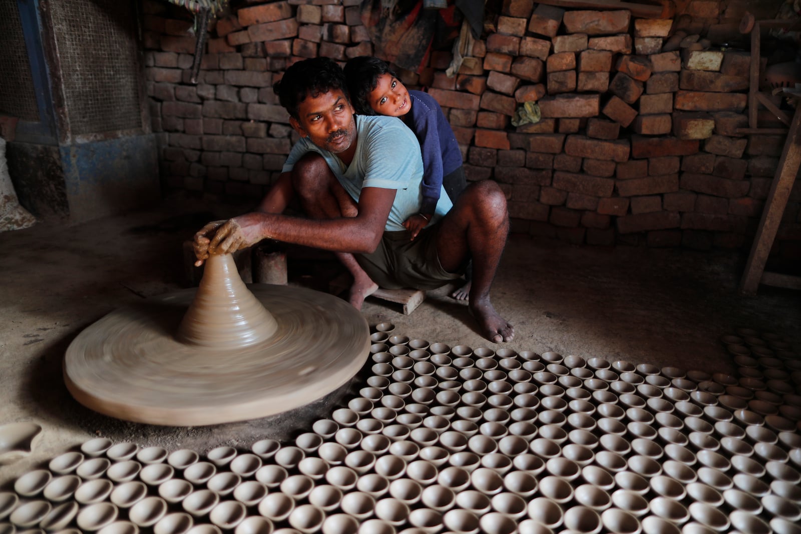 FILE- An Indian potter makes earthen lamps ahead of Diwali festival in Prayagraj, India, Oct. 27, 2021. (AP Photo/Rajesh Kumar Singh, File)