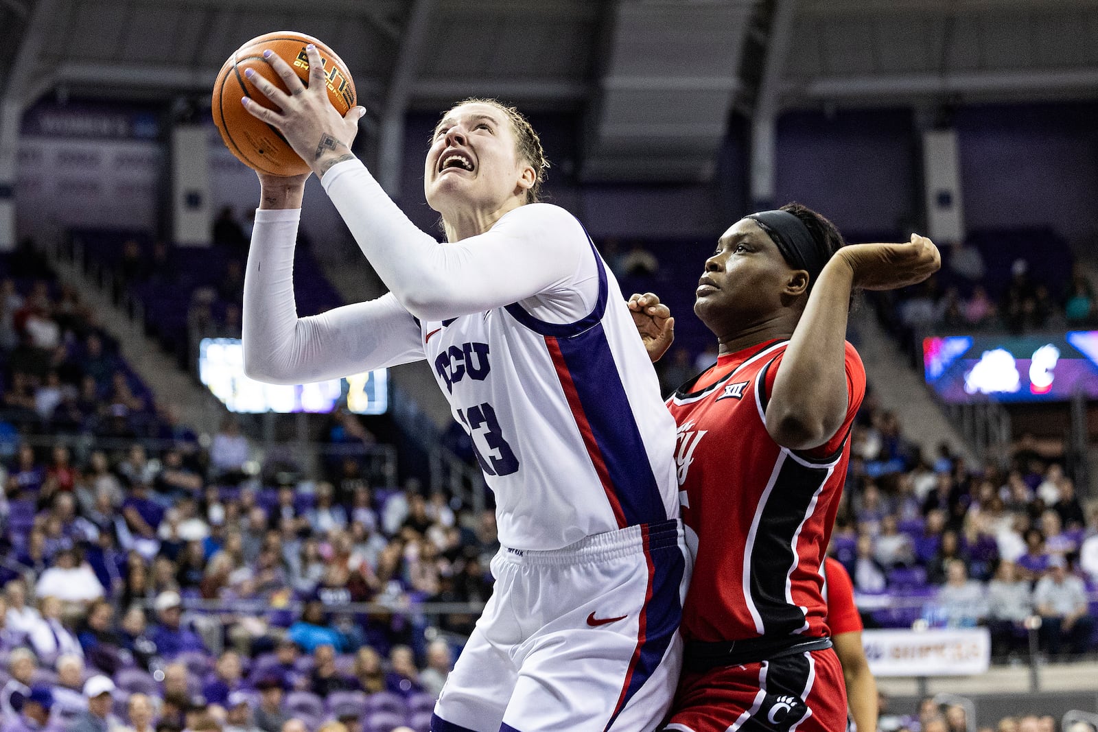 TCU center Sedona Prince (13) makes a post move on Cincinnati forward Alliance Ndiba (25) in the first half of an NCAA college basketball game Saturday, Jan. 4, 2025, in Fort Worth, Texas. (Chris Torres/Star-Telegram via AP)