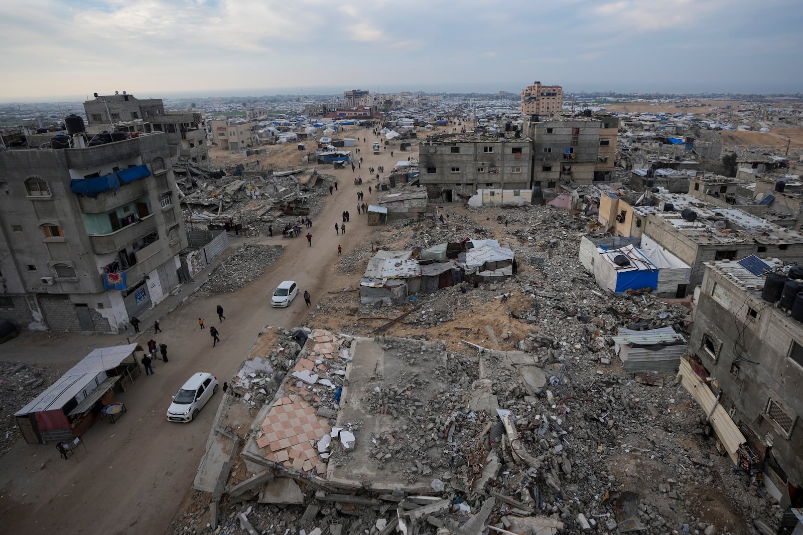 A tent camp for displaced Palestinians is set up amid destroyed buildings in the Khan Younis refugee camp, southern Gaza Strip, Saturday, Jan. 4, 2025. (AP Photo/Abdel Kareem Hana)