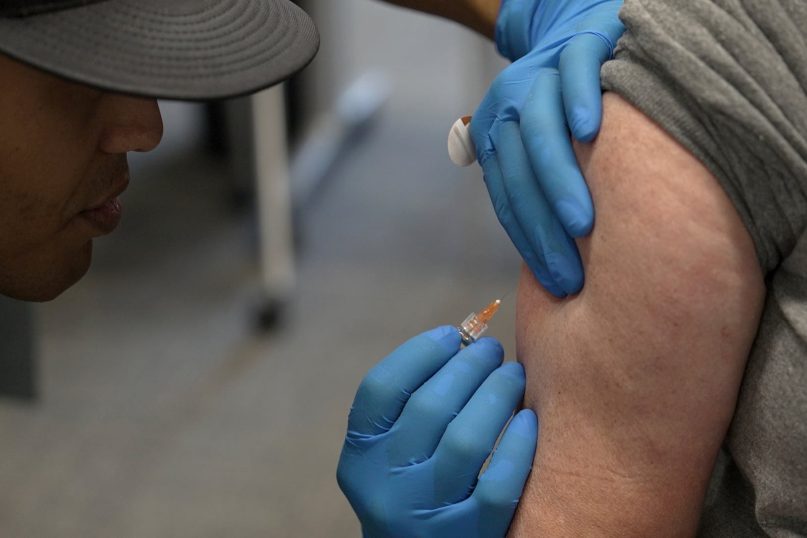 Matt Caldwell, left, a Lubbock Fire Department official, administers a measles, mumps and rubella vaccine to Clair May, 61, at the Lubbock Health Department, Wednesday, Feb. 26, 2025, in Lubbock, Texas. (AP Photo/Mary Conlon)