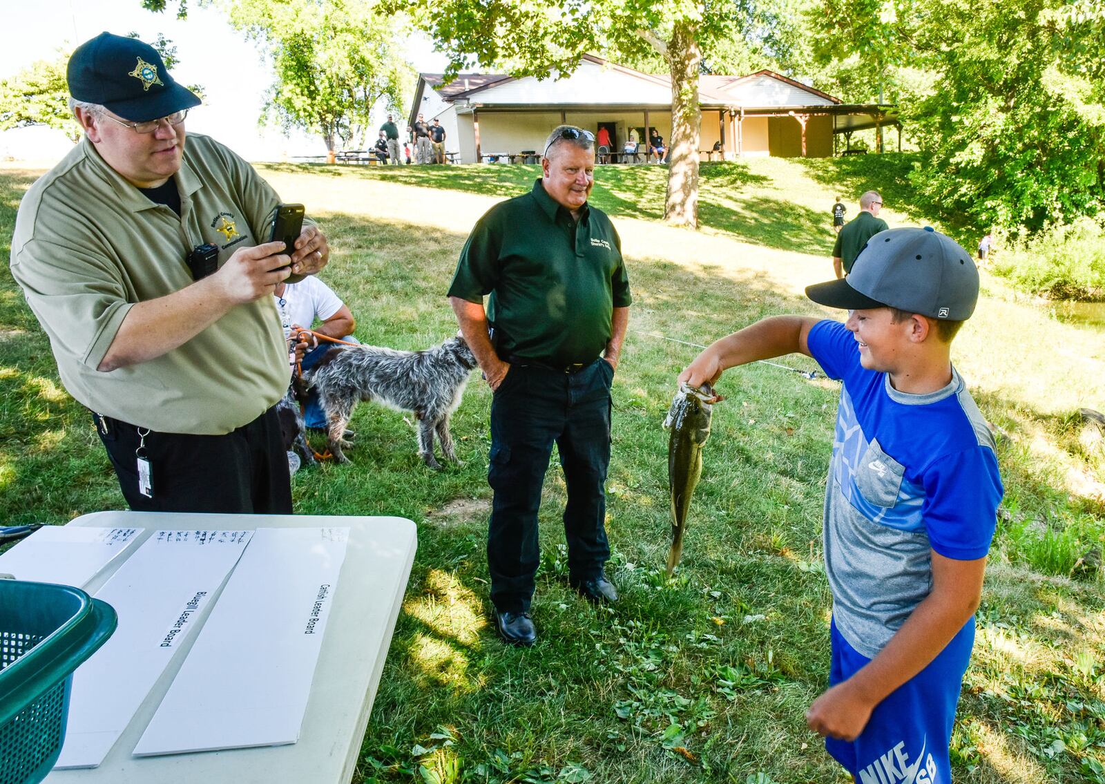 Jacob Baker rushes to get his fish weighed during the Fish with a Cop event Tuesday, July 17, at Fairfield Optimist Club pond. 