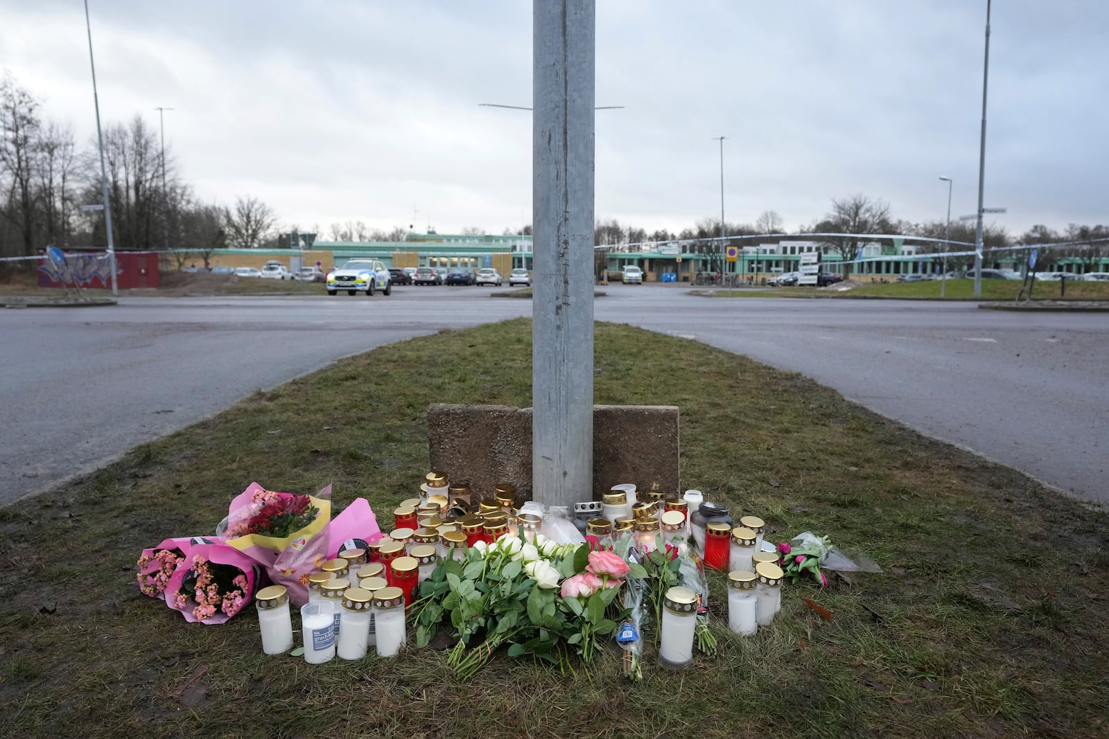 Flowers and candles are placed at a makeshift memorial near the scene of a shooting on the outskirts of Orebro, Sweden, Wednesday, Feb. 5, 2025. (AP Photo/Sergei Grits)