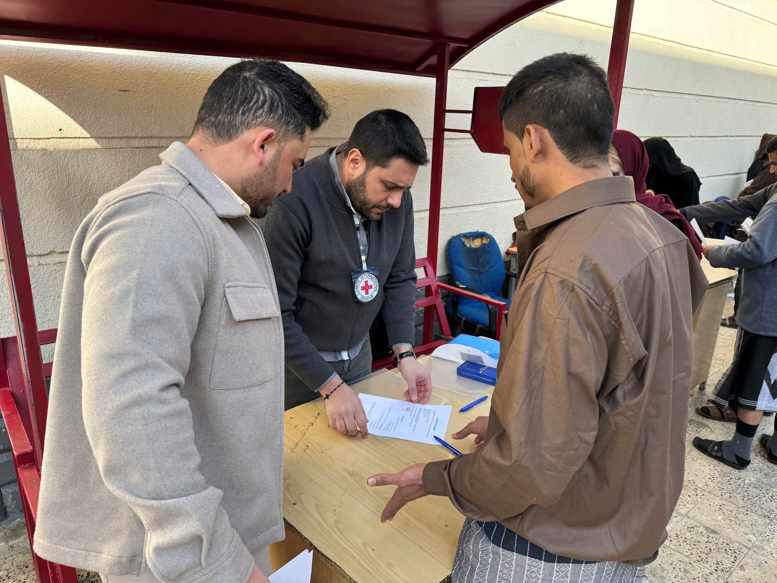 This photo released by the International Committee of the Red Cross shows its officials helping prisoners prepare to be freed by Yemen's Houthi rebels, in Sanaa, Yemen, Saturday, Jan. 25, 2025. (International Committee of the Red Cross via AP)