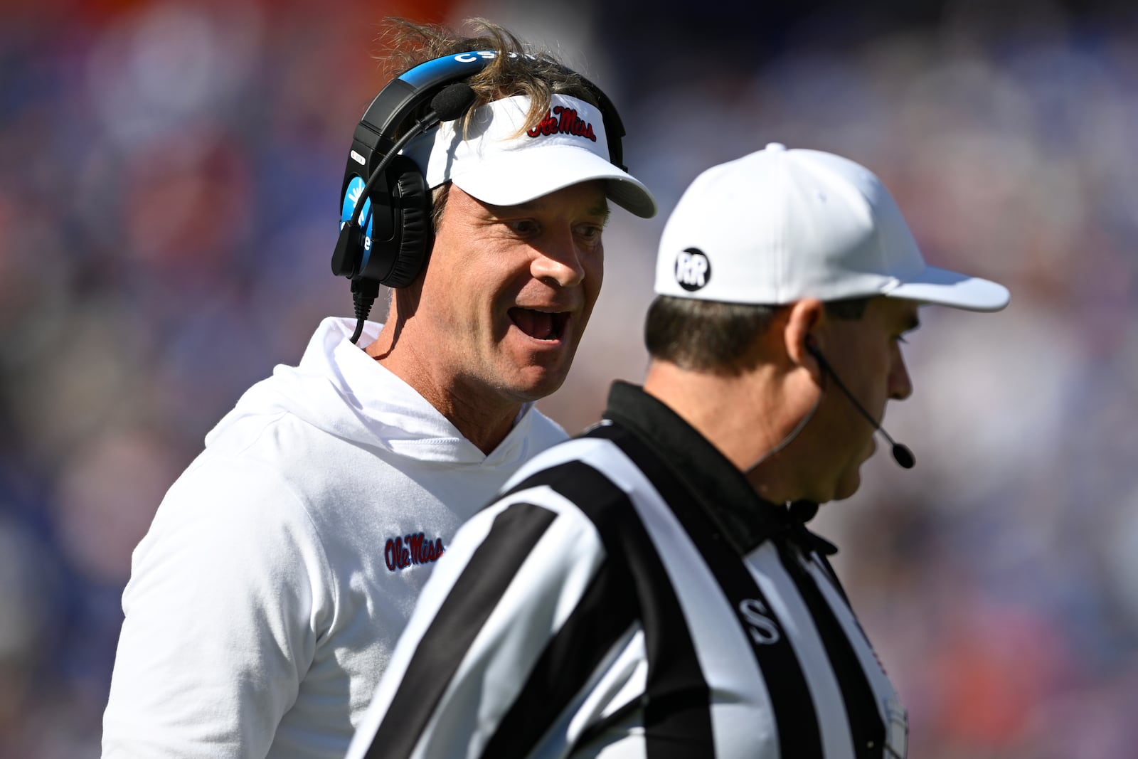 Mississippi head coach Lane Kiffin, left, questions an official on the sideline during the first half of an NCAA college football game against Florida, Saturday, Nov. 23, 2024, in Gainesville, Fla. (AP Photo/Phelan M. Ebenhack)