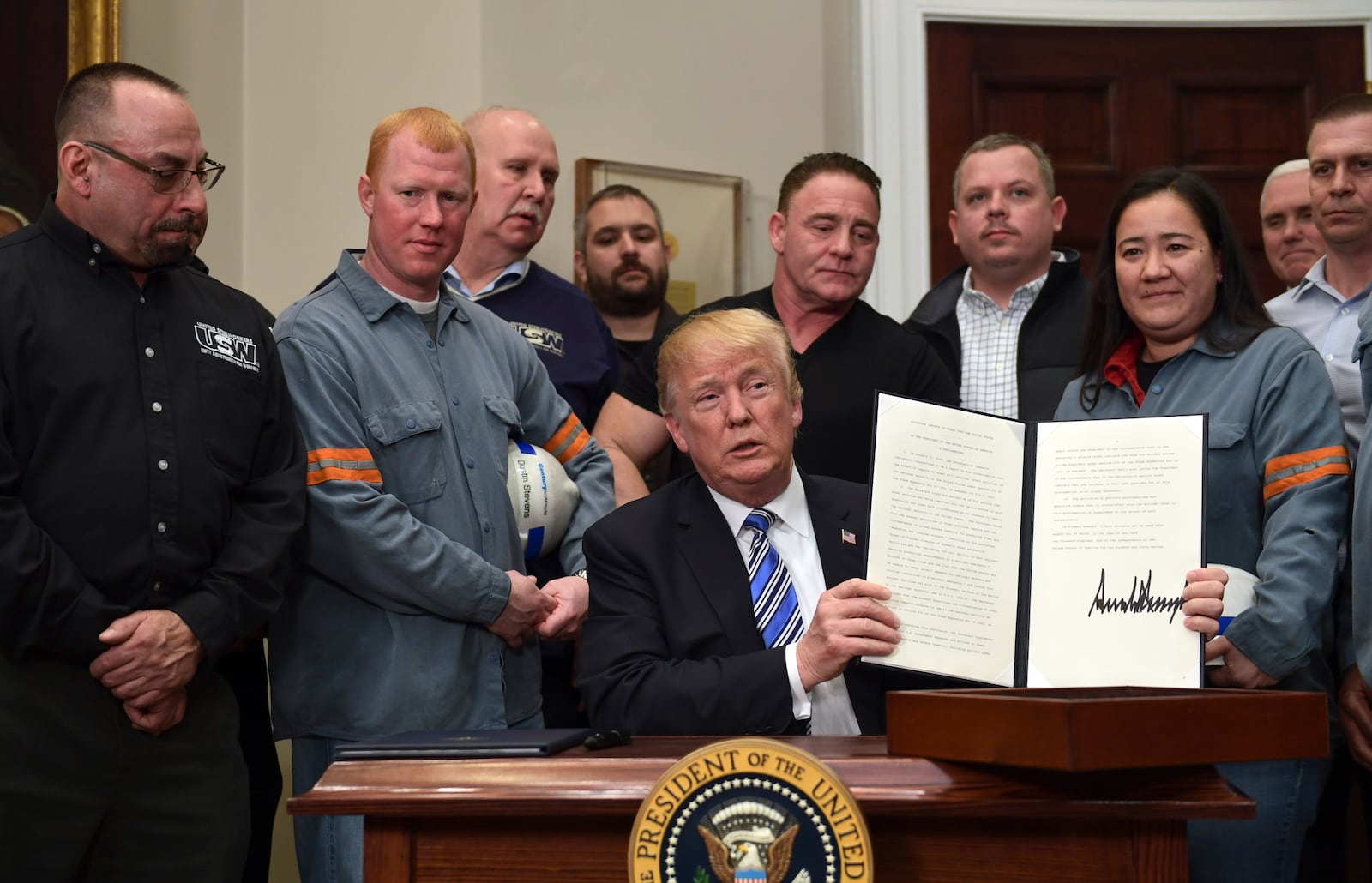 FILE - President Donald Trump holds up a proclamation on steel imports during an event at the White House in Washington, March 8, 2018. (AP Photo/Susan Walsh, File)