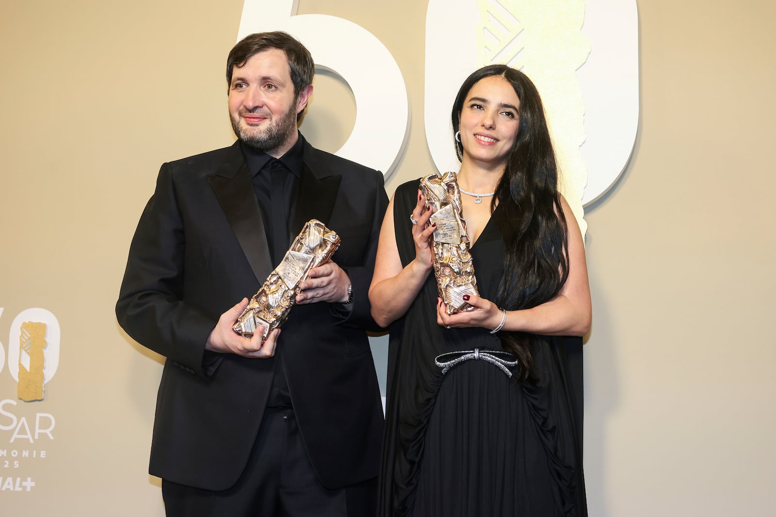 Karim Leklou winner of the Best Actor award for the movie "Le roman de Jim," poses with Hafsia Herzi, winner of the Best Actress award for the movie "Borgo," during the 50th Cesar Awards ceremony in Paris, early Saturday, March 1, 2025. (AP Photo/Thomas Padilla)