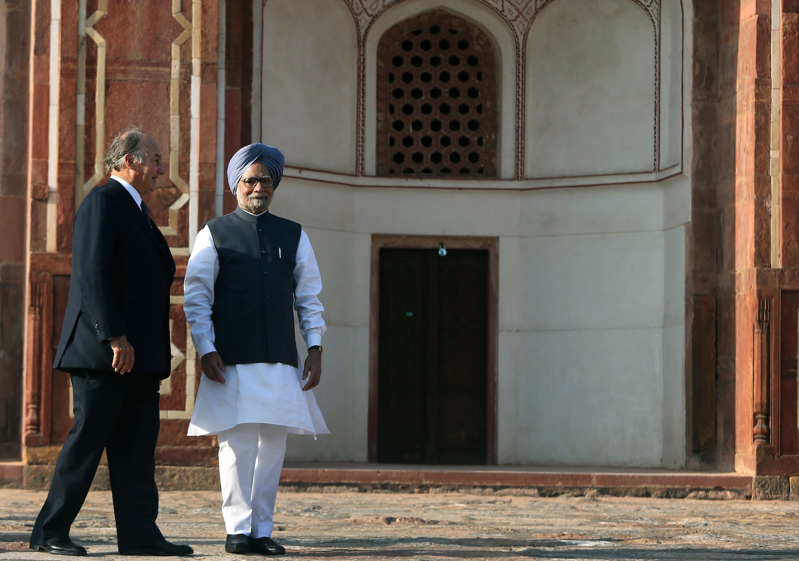 FILE - Indian Prime Minister Manmohan Singh, right, walks with the Aga Khan, spiritual head of Ismaili Muslims, as he arrives to inaugurate the restored 16th Century Humayun's Tomb in New Delhi, India, Wednesday, Sept. 18, 2013. (AP Photo/Manish Swarup, File)