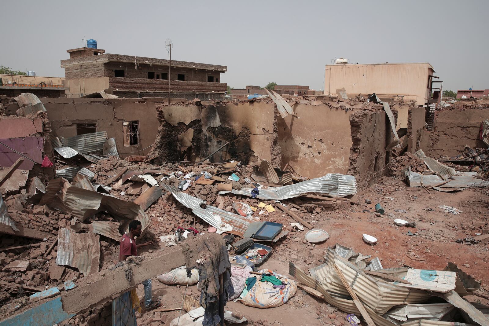 FILE - A man walks by a house hit in recent fighting in Khartoum, Sudan, an area torn by fighting between the military and the notorious paramilitary Rapid Support Forces, on April 25, 2023. (AP Photo/Marwan Ali, File)