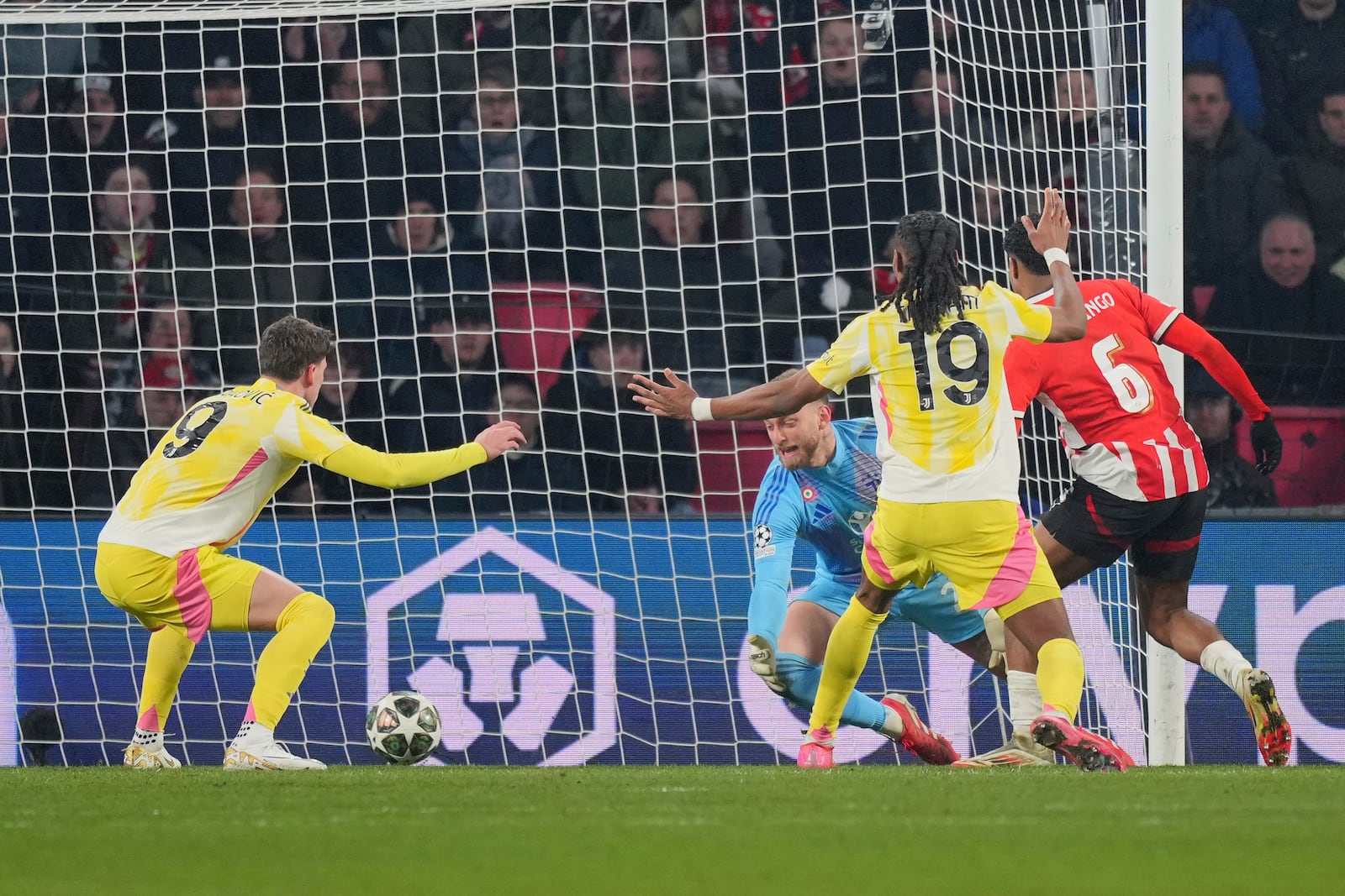 PSV's Ryan Flamingo, right, scores his side's third goal during the Champions League playoff second leg soccer match between PSV and Juventus at Phillips Stadium in Eindhoven, Netherlands, Wednesday, Feb.19, 2025. (AP Photo/Peter Dejong)