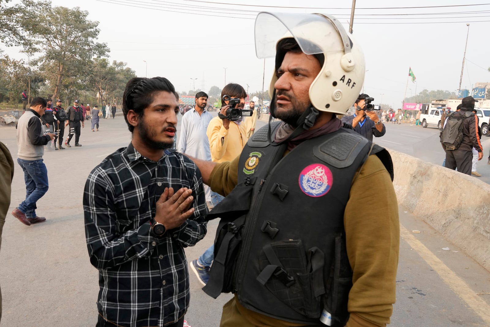 A police officer detains a supporter of imprisoned former premier Imran Khan's Pakistan Tehreek-e-Insaf party, which supporters gather for a rally demanding Khan's release, in Lahore, Pakistan, Sunday, Nov. 24, 2024. (AP Photo/K.M. Chaudary)