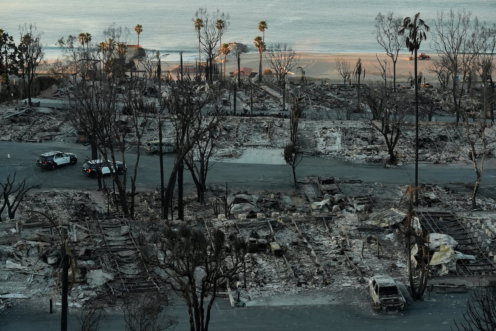 Los Angeles Police guard burned homes at the Pacific Palisades Bowl Mobile Estates destroyed by the Palisades Fire are seen in the Pacific Palisades neighborhood of Los Angeles, Thursday, Jan. 16, 2025. (AP Photo/Damian Dovarganes)