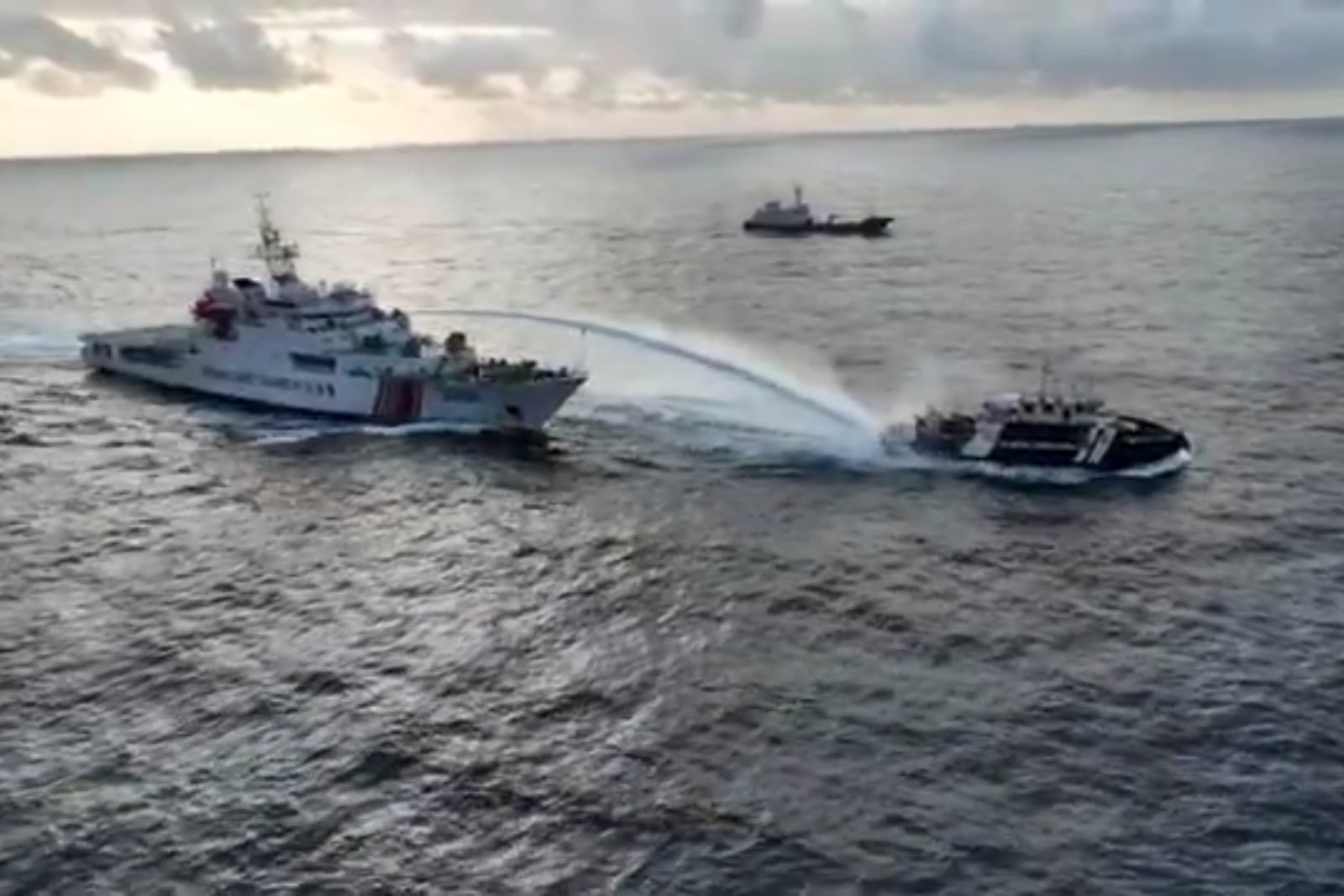 In this image made from a video provided by the National Task Force for the West Philippine Sea (NTF-WPS), a Chinese coast guard vessel, left, fires a powerful water cannon on a Philippine bureau of fisheries vessel near a disputed shoal in the South China Sea Wednesday Dec. 4, 2024. (National Task Force for the West Philippine Sea via AP)