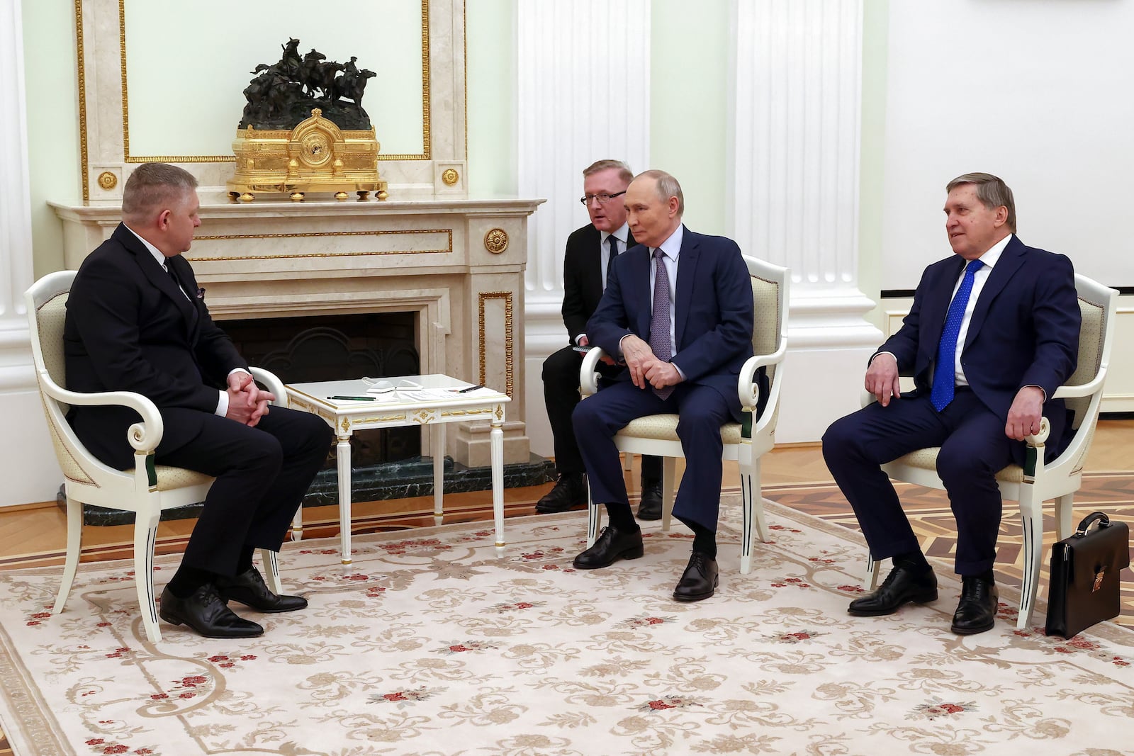 Russian President Vladimir Putin, center, and Slovak Prime Minister Robert Fico, left, talk to each other as Presidential aide Yuri Ushakov, right, attends the talks at the Kremlin in Moscow, Russia, Sunday, Dec. 22, 2024. (Artyom Geodakyan, Sputnik, Government Pool Photo via AP)