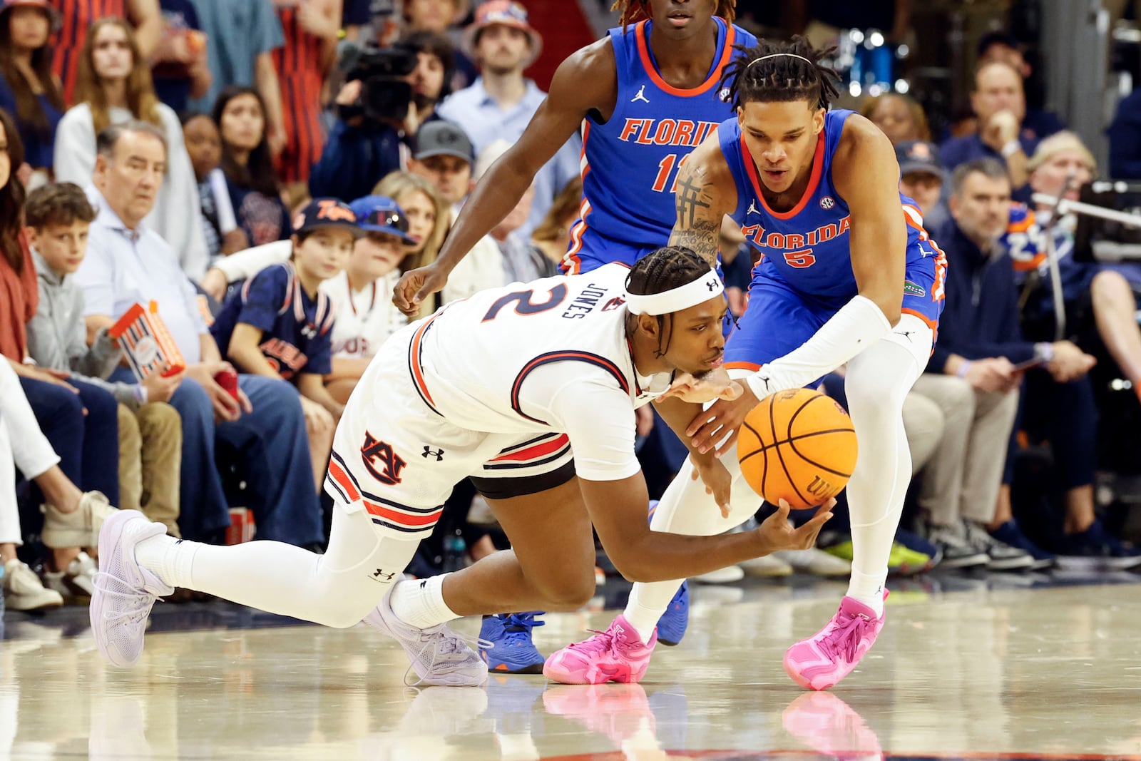 Auburn guard Denver Jones (2) and Florida guard Will Richard (5) battle for a loose ball during the first half of an NCAA college basketball game, Saturday, Feb. 8, 2025, in Auburn, Ala. (AP Photo/Butch Dill)