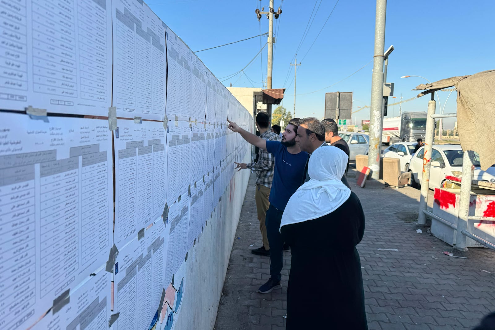 People check candidates lists during parliamentary elections of Iraq’s semi-autonomous northern Kurdish region, in Irbil, Sunday, Oct. 20, 2024. (AP Photo/Salar Salim)