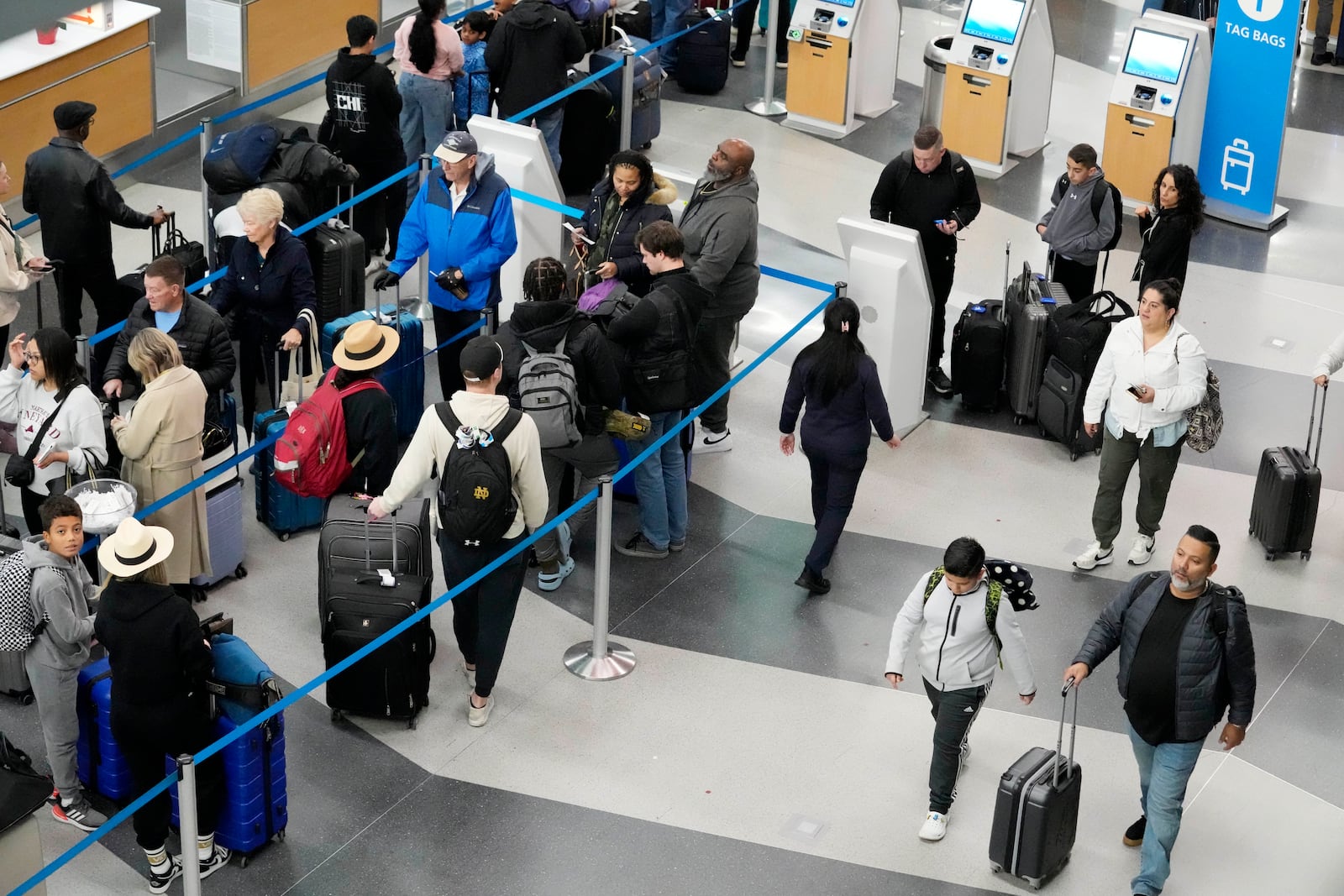 Travelers wait to drop off their bags and walk through Terminal 3 at O'Hare International Airport in Chicago, Tuesday, Nov. 26, 2024. (AP Photo/Nam Y. Huh)