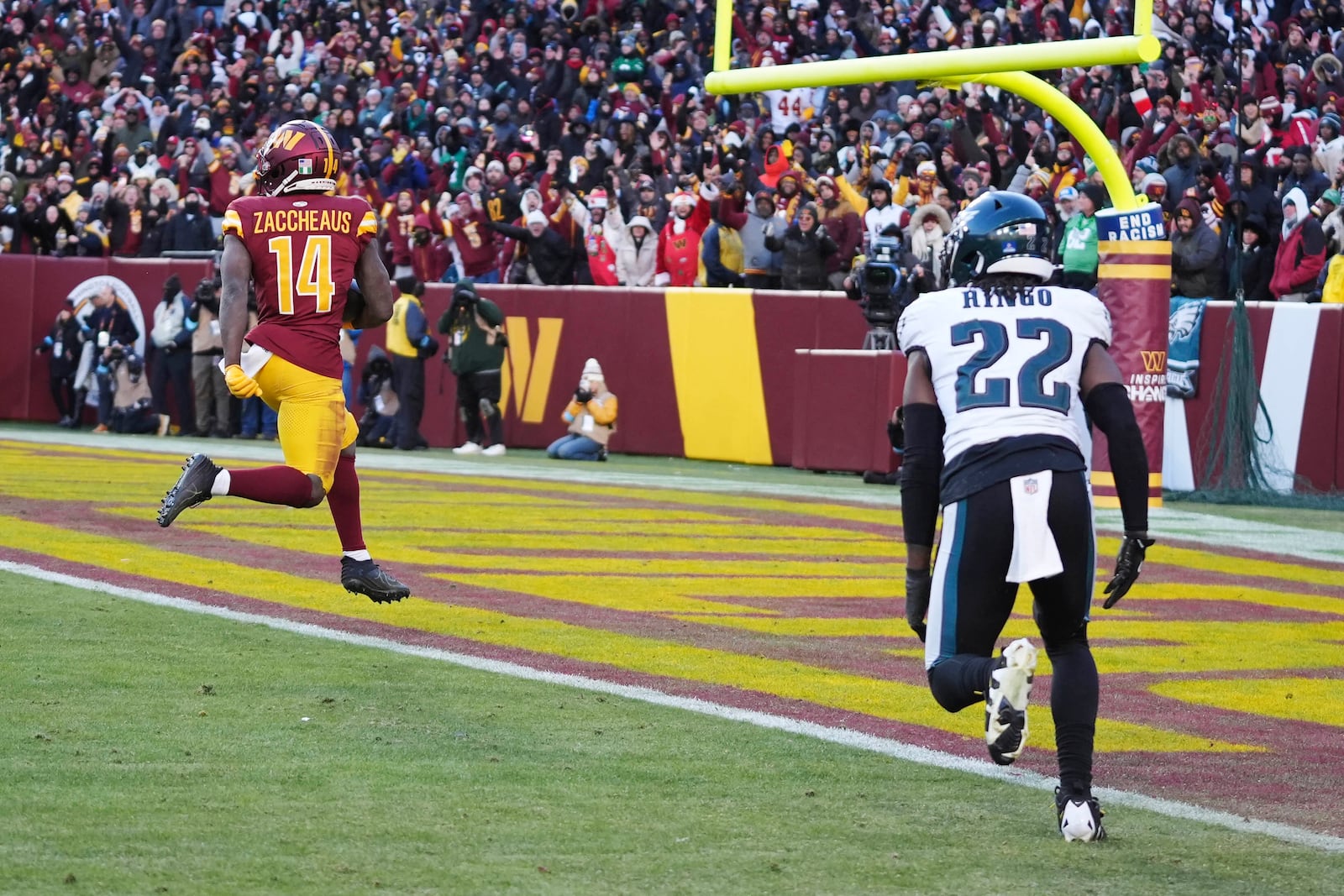 Washington Commanders wide receiver Olamide Zaccheaus (14) scores a touchdown against Philadelphia Eagles cornerback Kelee Ringo (22) during the second half of an NFL football game, Sunday, Dec. 22, 2024, in Landover, Md. (AP Photo/Stephanie Scarbrough)