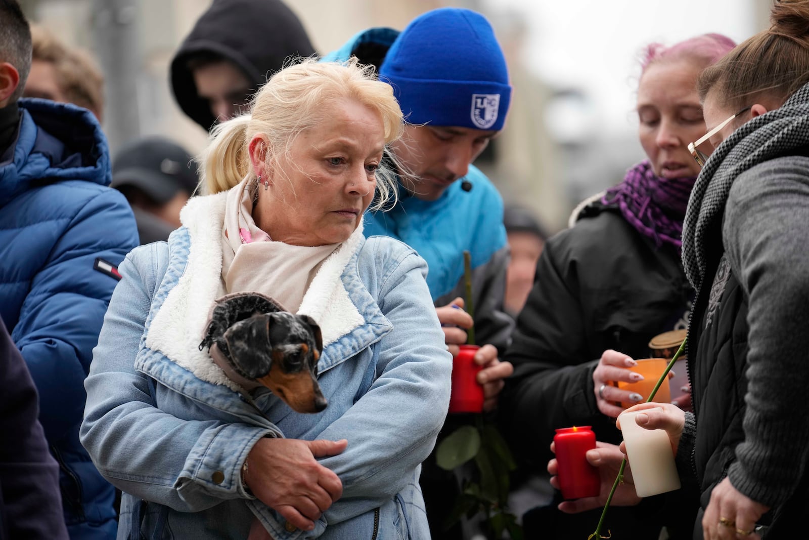 Citizens pay tribute for deaths outside St. John's Church near a Christmas Market, where a car drove into a crowd on Friday evening, in Magdeburg, Germany, Saturday, Dec. 21, 2024. (AP Photo/Ebrahim Noorozi)