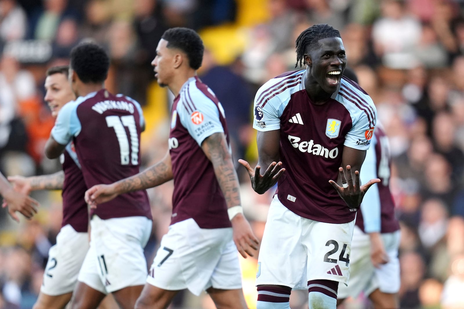 Aston Villa's Amadou Onana celebrates their side's third goal of the game, via an own-goal scored by Fulham's Issa Diop during the English Premier League soccer match between Fulham and Aston Villa at Craven Cottage in London, Saturday Oct. 19, 2024. (John Walton/PA via AP)