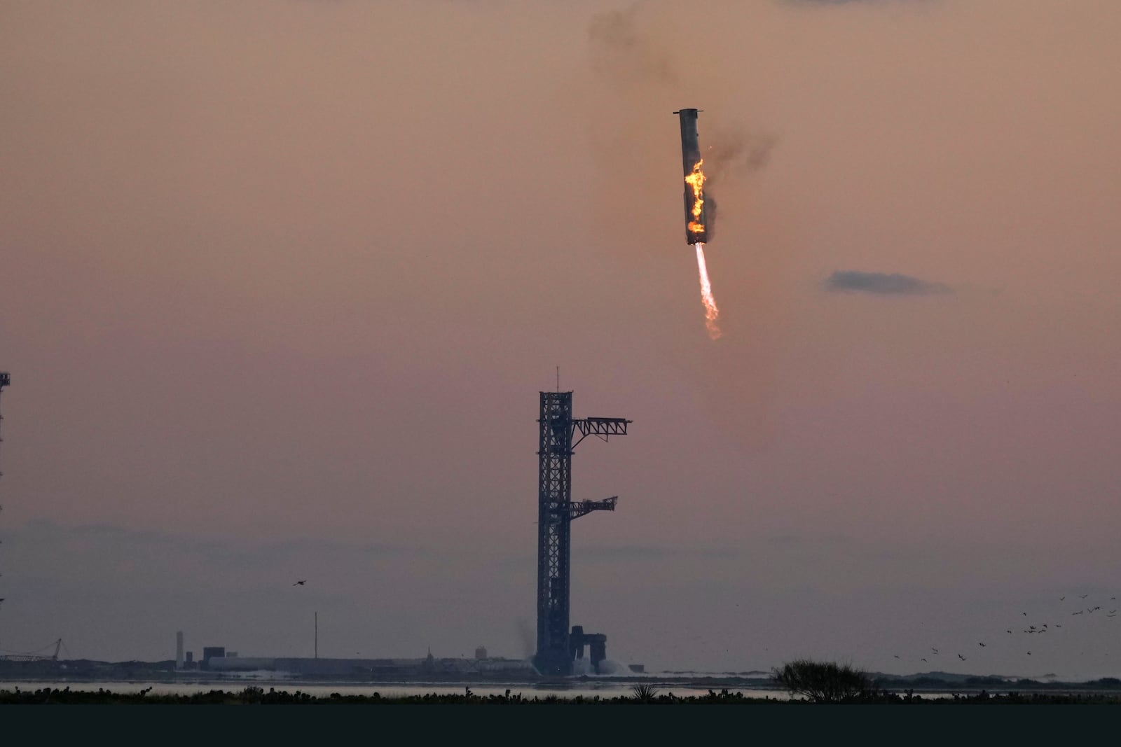 SpaceX's mega rocket booster returns to the launch pad to be captured during a test flight Sunday, Oct. 13, 2024, in Boca Chica,, Texas. (AP Photo/Eric Gay)