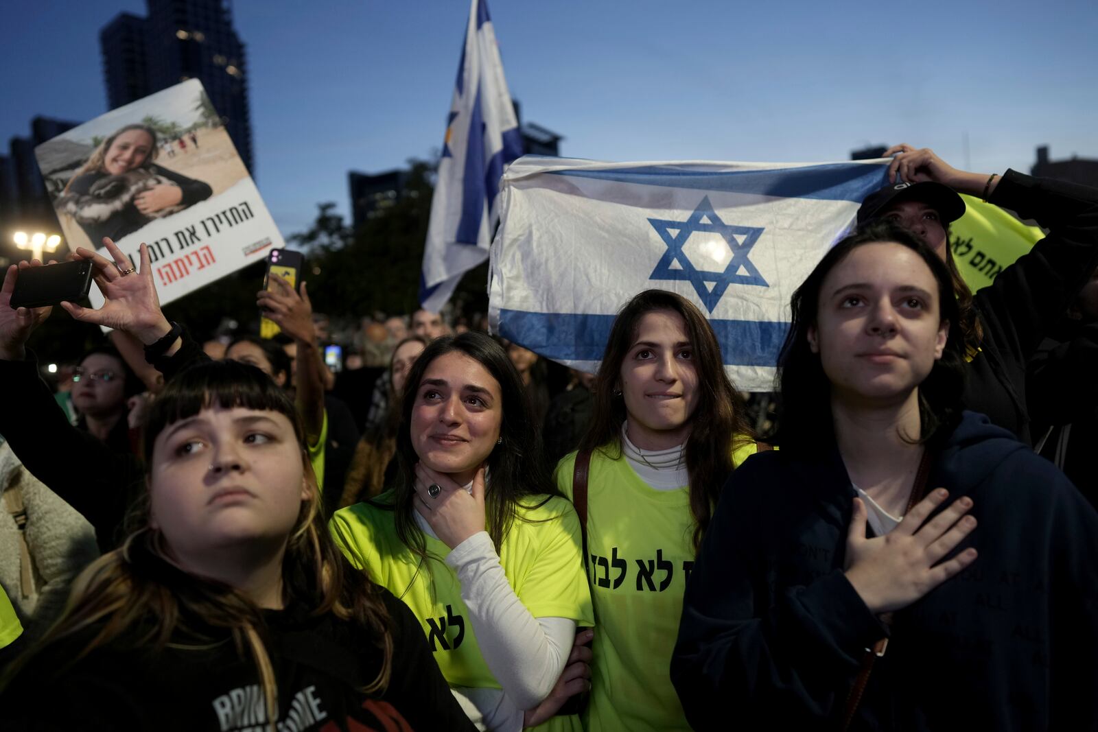 Relatives and friends of people killed and abducted by Hamas and taken into Gaza, react to the news of the hostages' release, as they gather in Tel Aviv, Israel on Sunday, Jan. 19, 2025. (AP Photo/Oded Balilty)