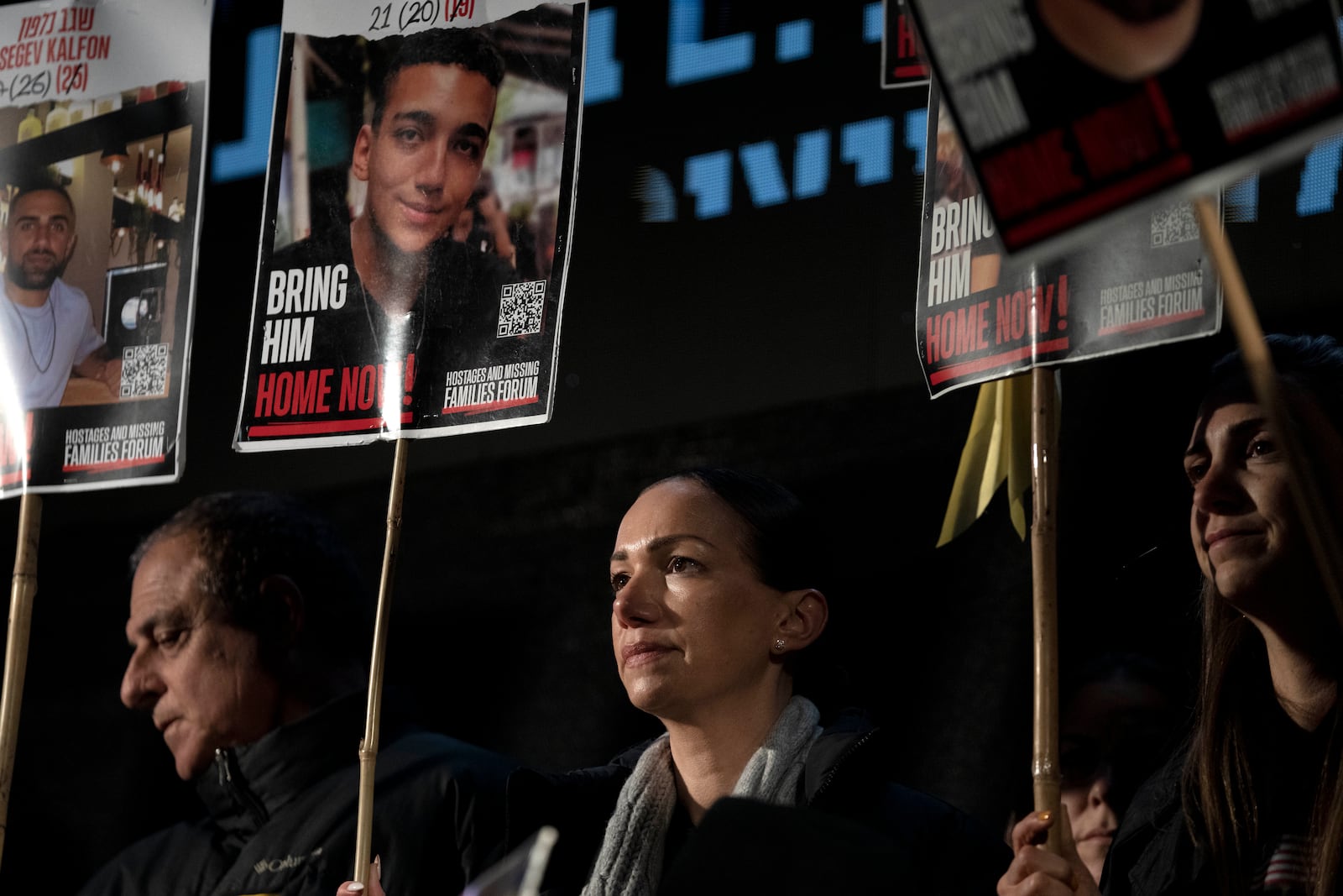 Yael Alexander holds a poster of her son, Edan, who was taken hostage by Hamas militants on Oct. 7, 2023, during a weekly rally for families of hostages held in the Gaza Strip and their supporters, in Tel Aviv, Israel, Saturday, Feb. 22, 2025. (AP Photo/Maya Alleruzzo)