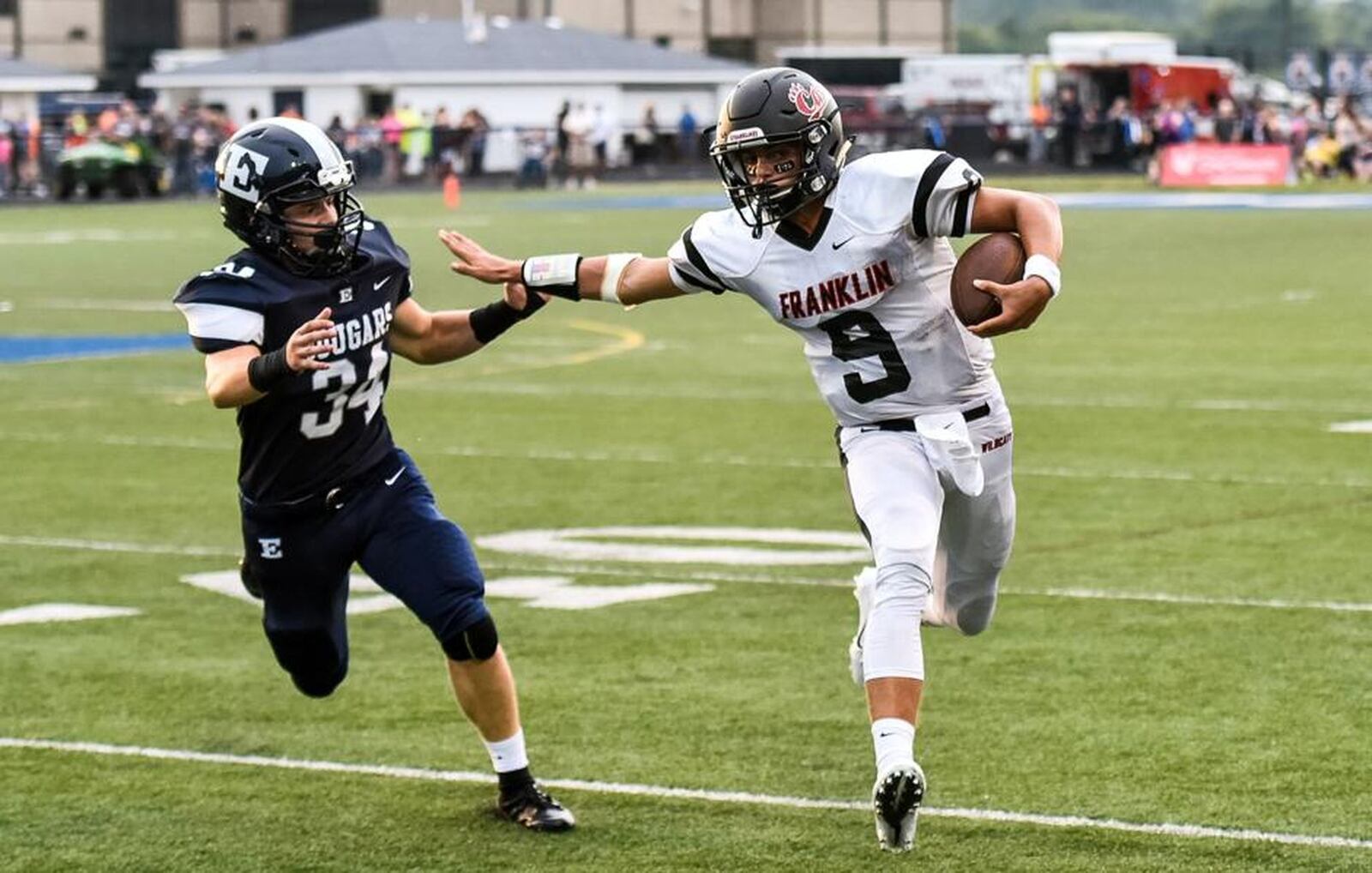 Franklin quarterback Braden Woods (9) tries to get away from Edgewood’s Peyton Hatfield on Friday night at Kumler Field in St. Clair Township. NICK GRAHAM/STAFF