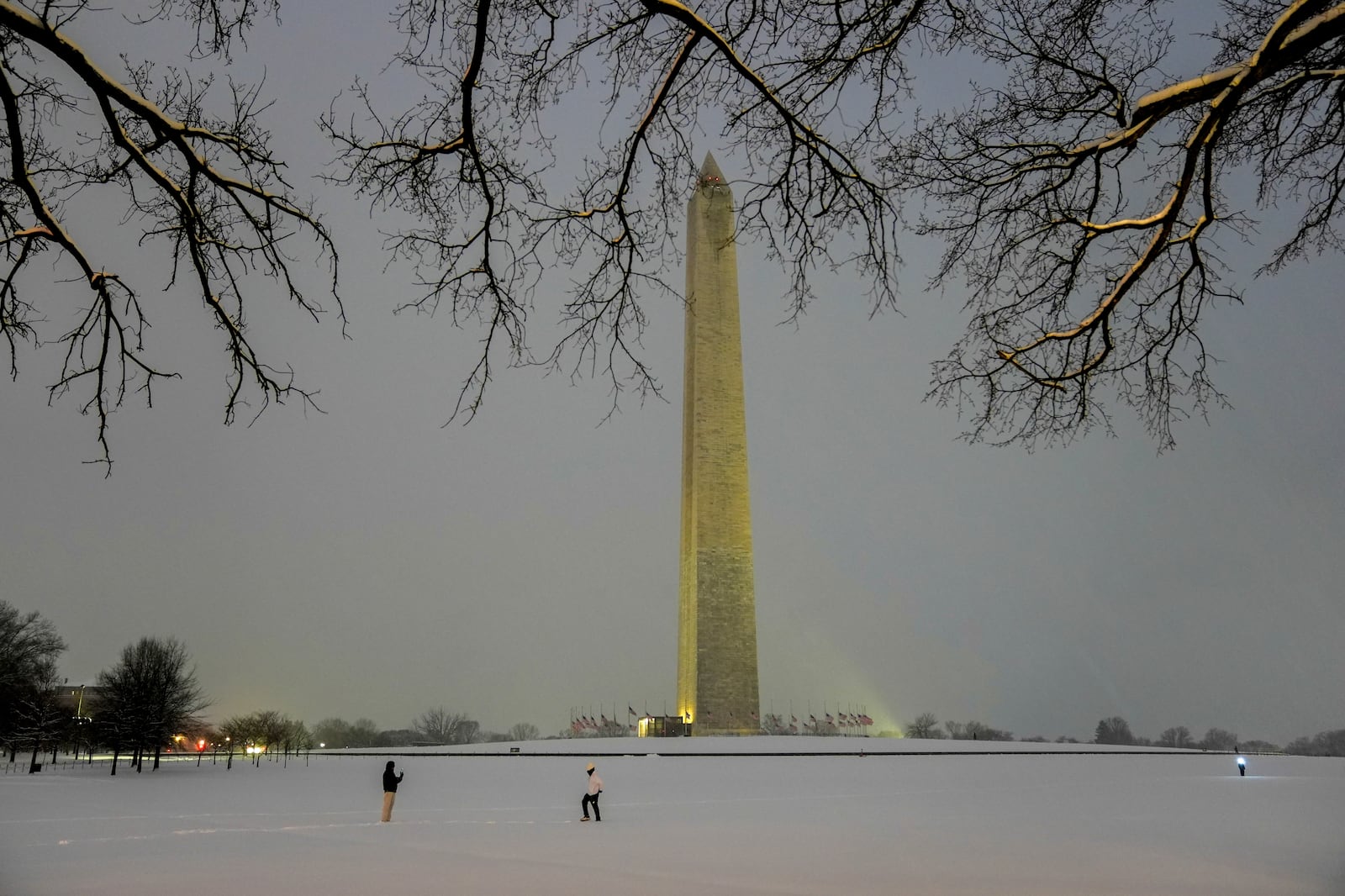 FILE - People walk near the Washington Monument during a winter snow storm in Washington, Jan. 6, 2025. (AP Photo/Matt Rourke, File)