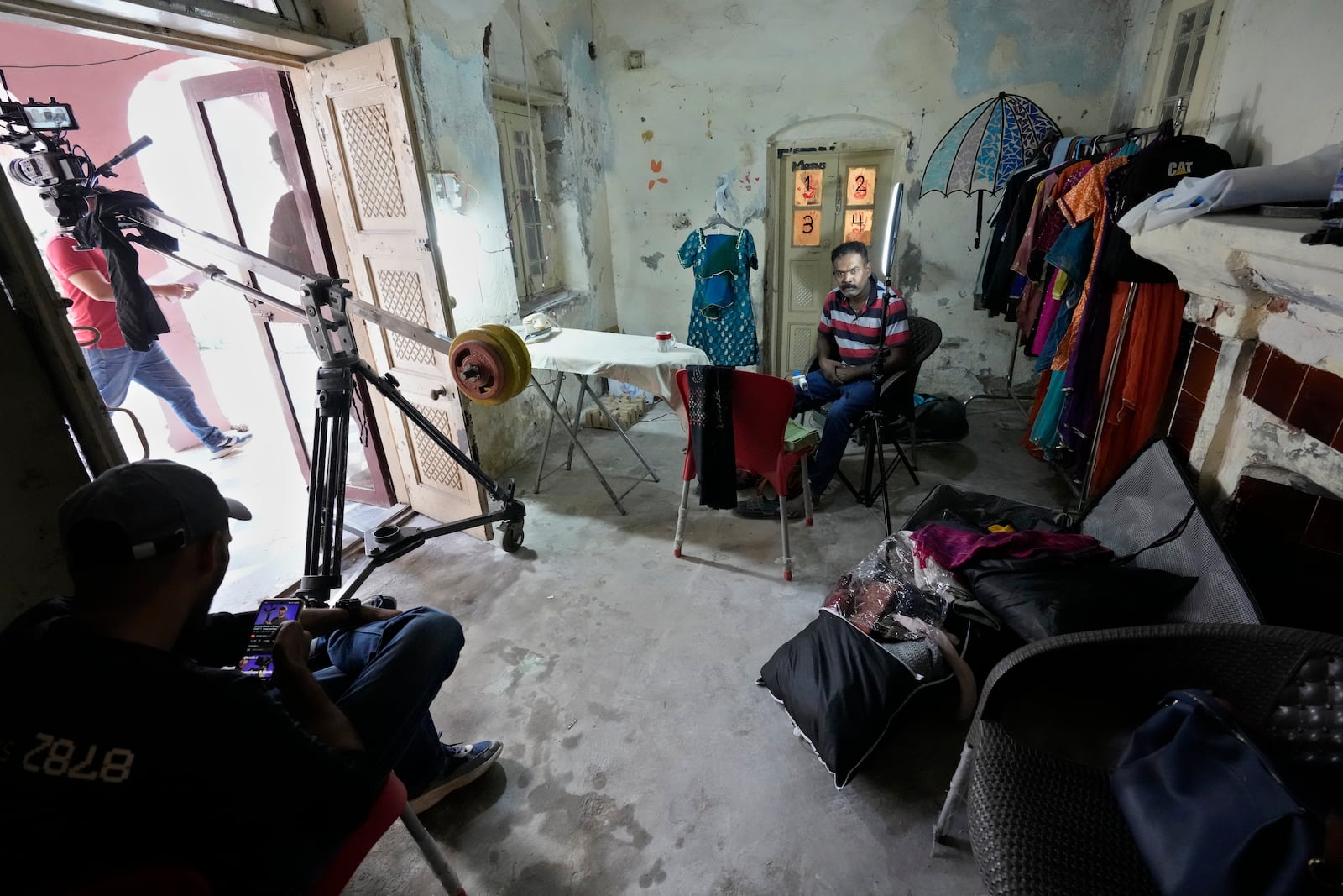 Technicians take a break during the shooting of a scene of tv drama serial ''Tan Man Neel-o-Neel' or Deeply Engrossed in Love',, in Rawalpindi, Pakistan, Saturday, Nov. 2, 2024. (AP Photo/Anjum Naveed)