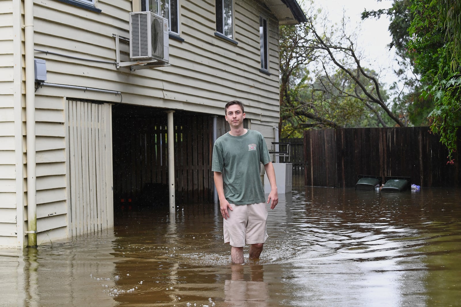 Hayden Edwards stands in flood waters outside his home in the Brisbane suburb of Oxley, Australia, Monday, March 10, 2025. (Jono Searle/AAP Image via AP)