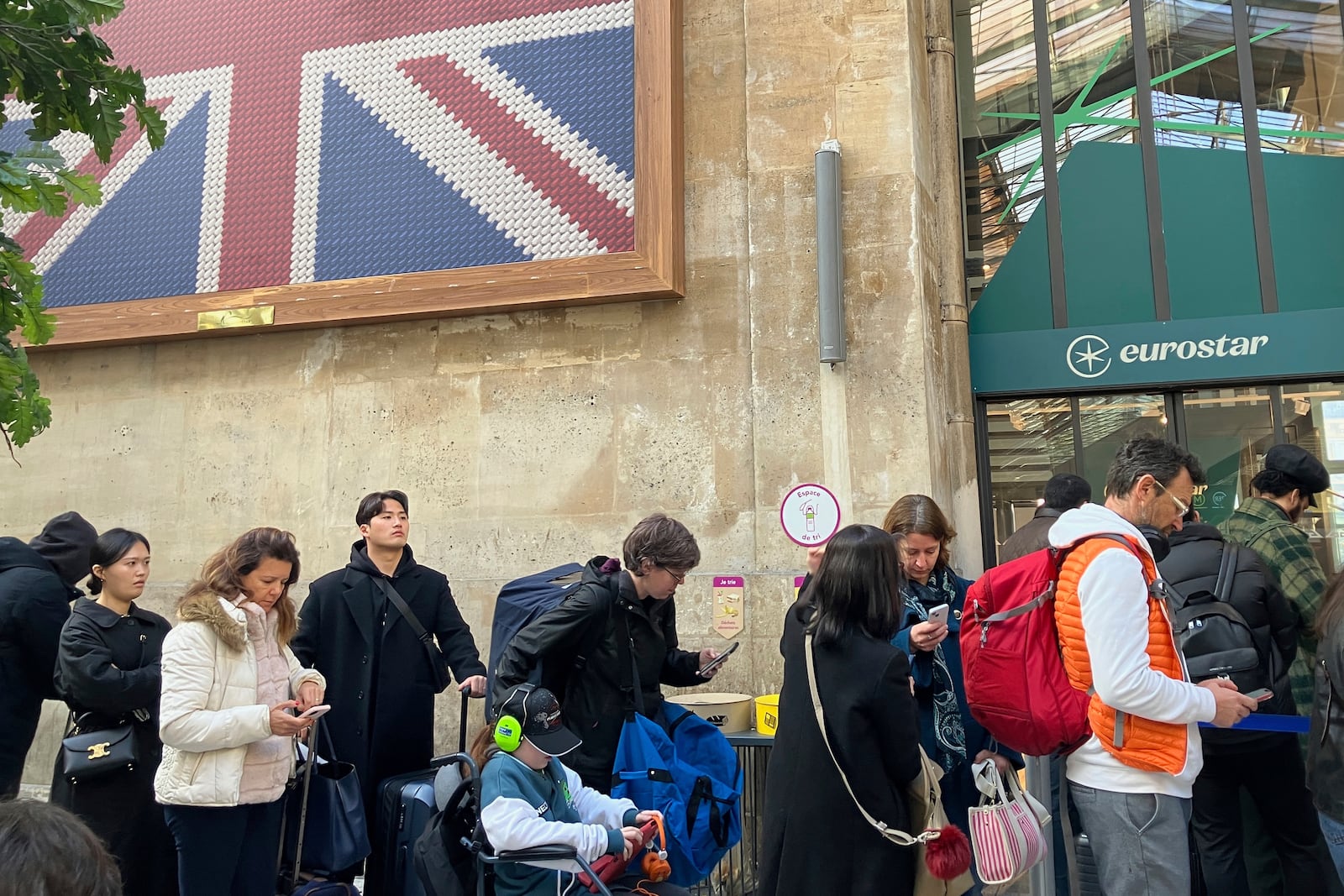 Travelers wait as Eurostar trains to London and all trains heading to northern France have been brought to a halt following the discovery of an unexploded bomb dating back to World War II near the tracks, Friday, March 7, 2025 at the Gare du Nord station in Paris. (AP Photo/Christophe Ena)