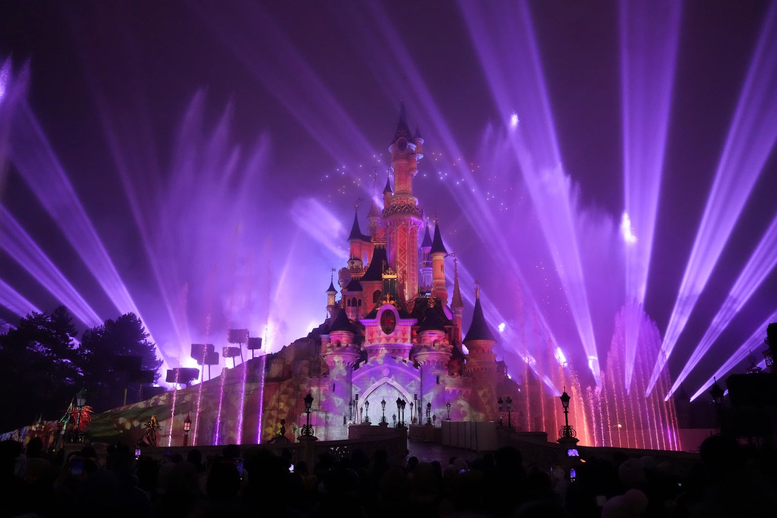 A light show is projected on the castle of Sleeping Beauty as fireworks explode in Disneyland, in Marne-la-Vallee, east of Paris, Friday Jan. 17, 2025. (AP Photo/Thibault Camus)