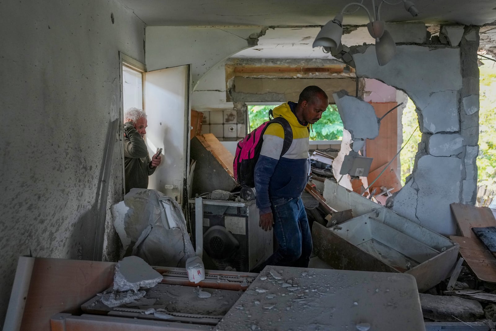 A resident enters the apartment he rents after a rocket fired from Lebanon hit a residential building in Kiryat Shmona, a town located near to the border with Lebanon, in northern Israel, Wednesday, Nov. 20, 2024. (AP Photo/Ohad Zwigenberg)