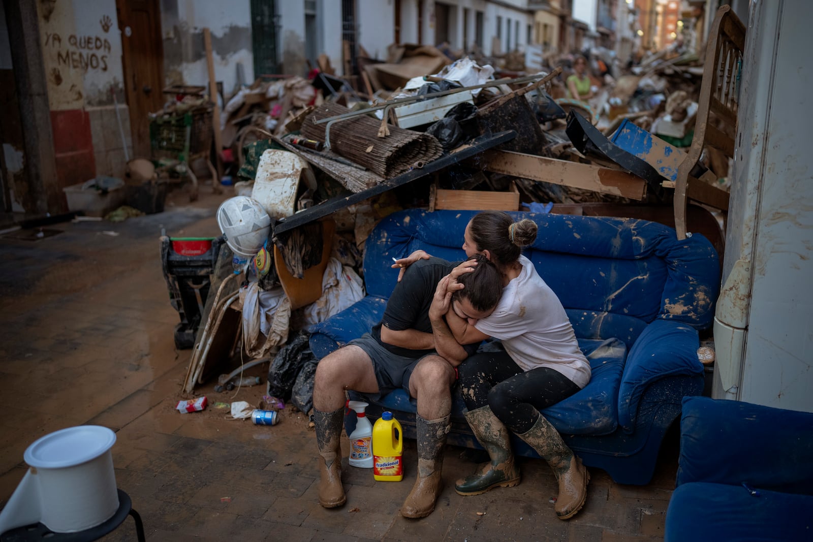 Tania hugs her brother-in-law Baruc after rescuing some of their belongings from their flooded house after the floods in Paiporta, Valencia, Spain, Tuesday, Nov. 5, 2024. (AP Photo/Emilio Morenatti)