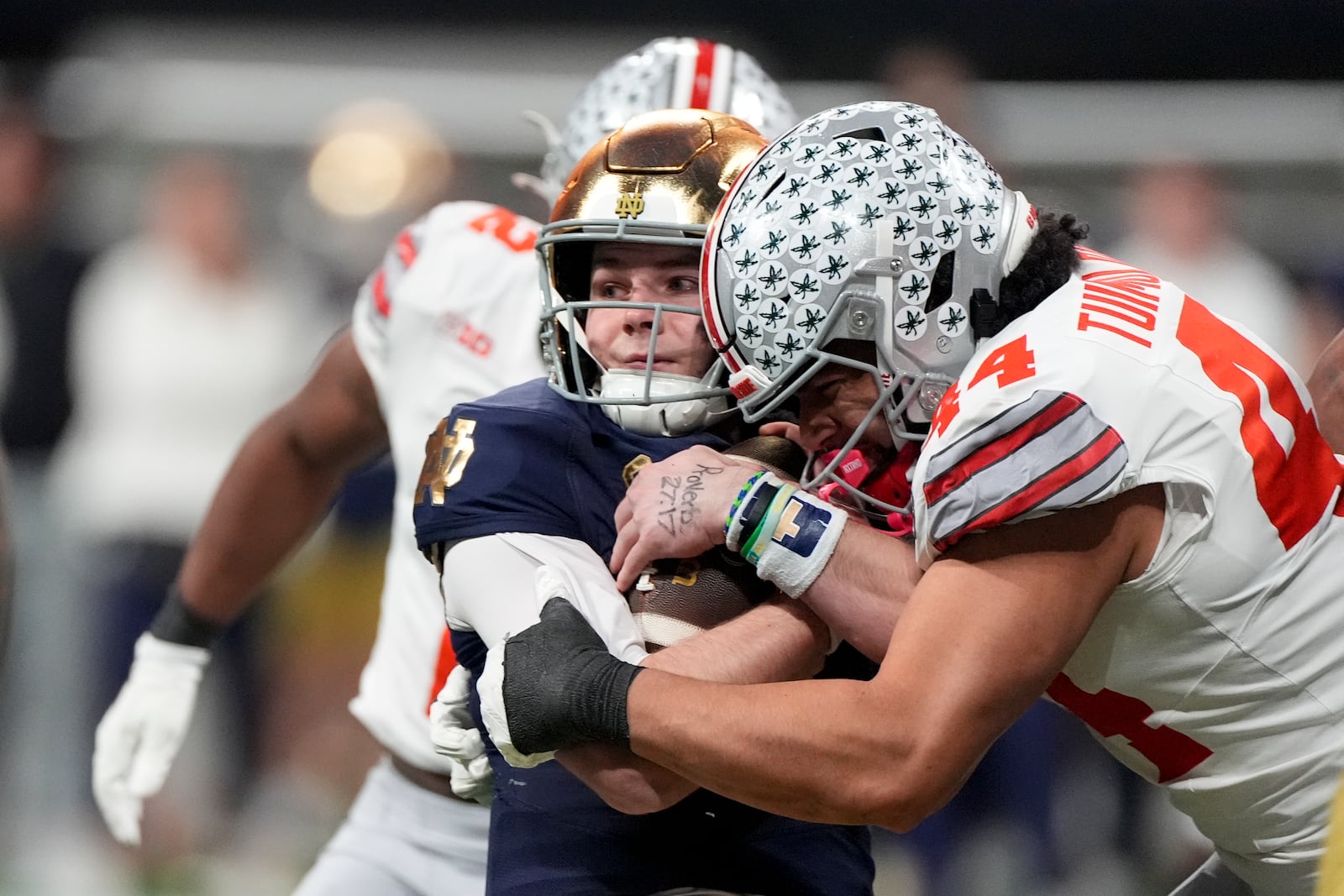 Notre Dame quarterback Riley Leonard is tackled by Ohio State defensive end JT Tuimoloau during first half of the College Football Playoff national championship game Monday, Jan. 20, 2025, in Atlanta. (AP Photo/Brynn Anderson)