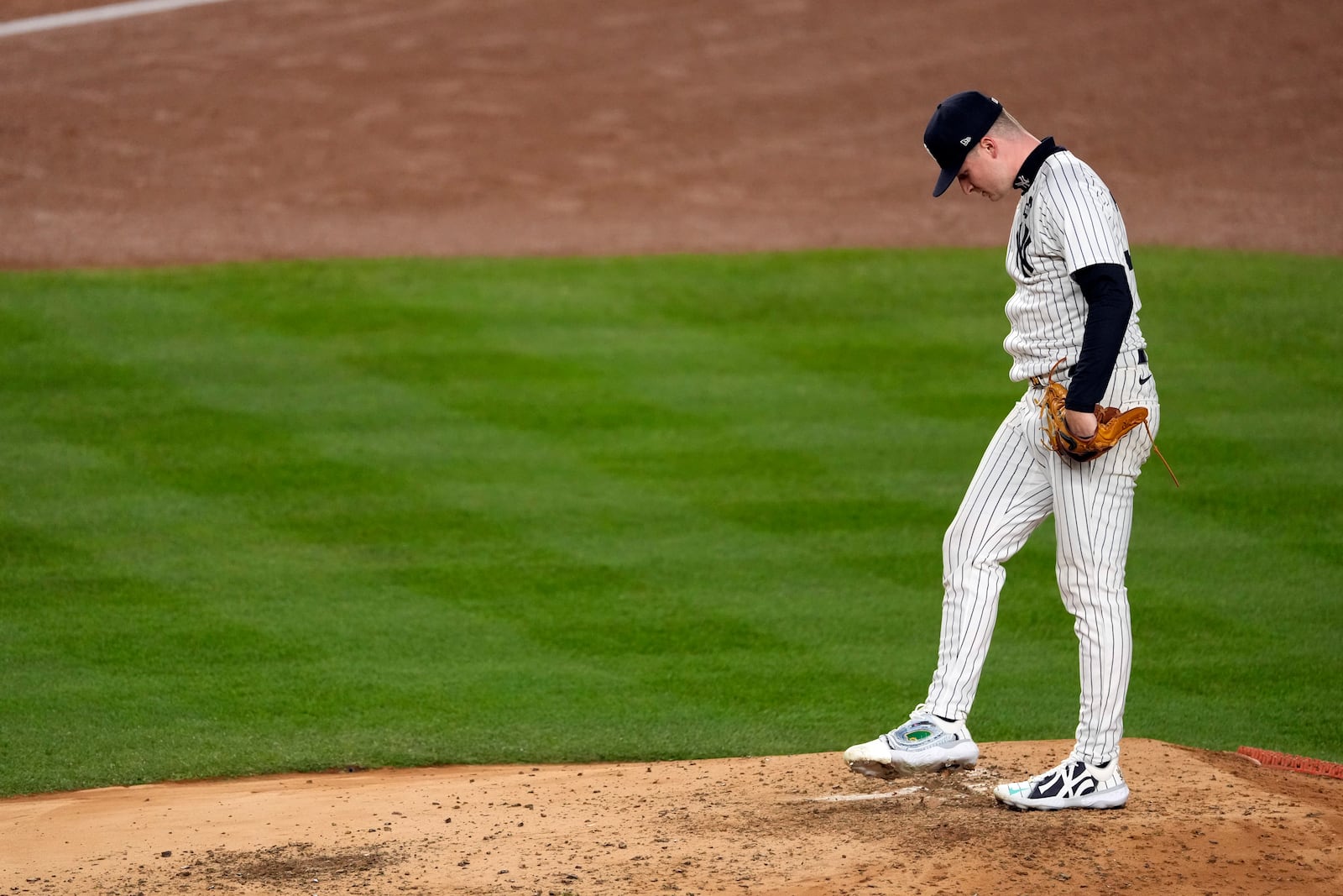 New York Yankees starting pitcher Clarke Schmidt waits for manager Aaron Boone to make his way to the mound to pull him during the third inning in Game 3 of the baseball World Series against the Los Angeles Dodgers, Monday, Oct. 28, 2024, in New York. (AP Photo/Seth Wenig)