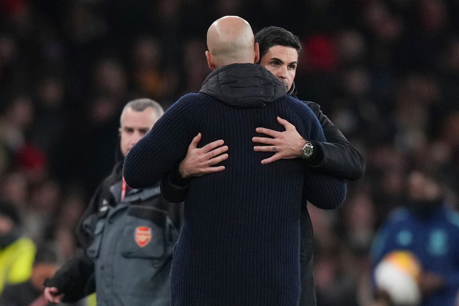 Arsenal's manager Mikel Arteta, background, hugs Manchester City's head coach Pep Guardiola at the end of the English Premier League soccer match between Arsenal and Manchester City at the Emirates stadium in London, Sunday, Feb. 2, 2025. (AP Photo/Alastair Grant)