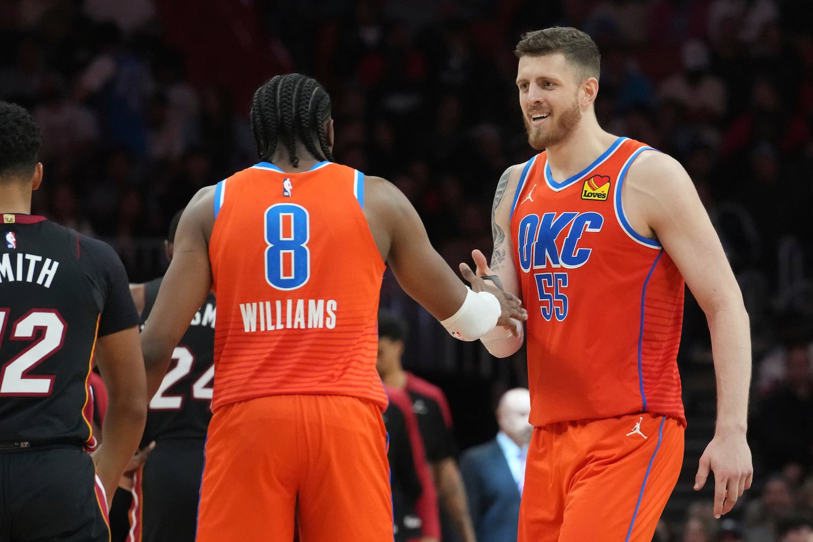 Oklahoma City Thunder forward Jalen Williams (8) and center Isaiah Hartenstein (55) celebrate during a timeout during the second half of an NBA basketball game against the Miami Heat, Friday, Dec. 20, 2024, in Miami. (AP Photo/Marta Lavandier)