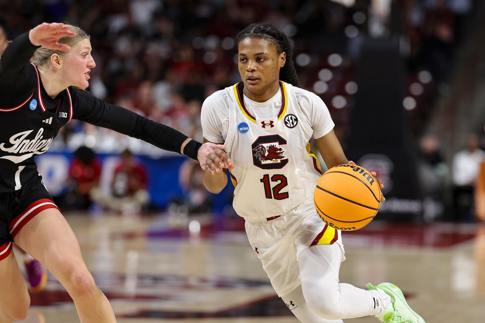 South Carolina guard MiLaysia Fulwiley (12) drives the ball around Indiana guard Lexus Bargesser (1) during the first half in the second round of the NCAA college basketball tournament, Sunday, March 23, 2025, in Columbia, S.C. (AP Photo/David Yeazell)