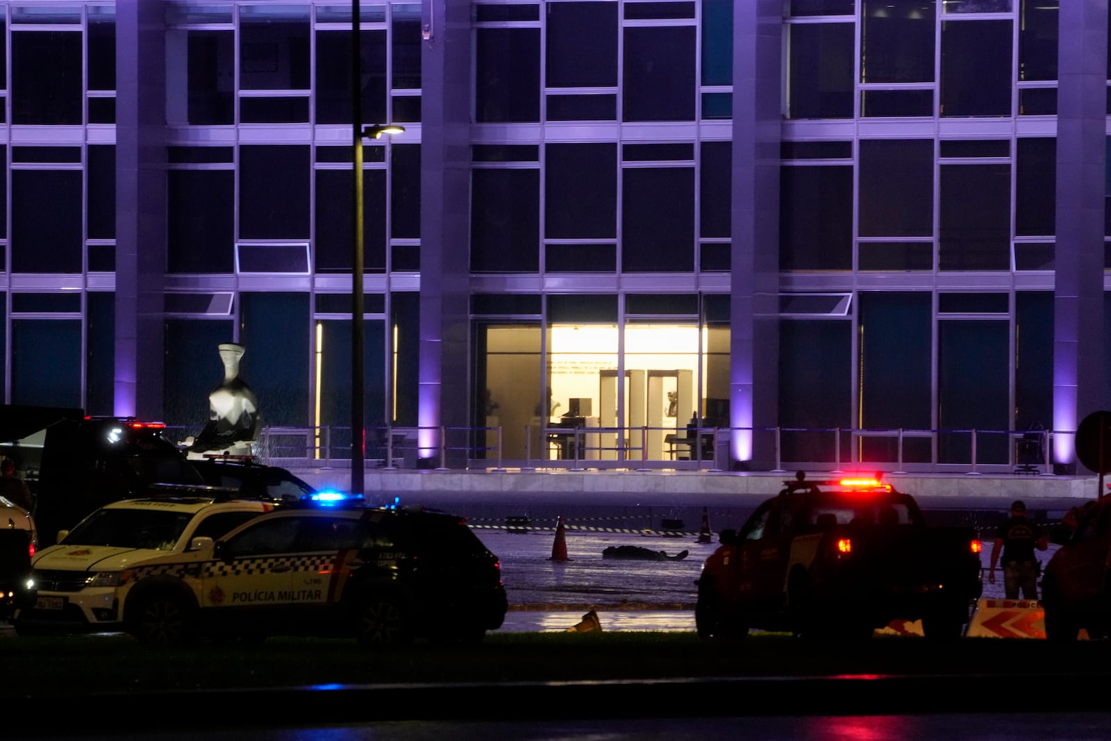 A body lies outside the Supreme Court in Brasília, Brazil, following an explosion, Wednesday, Nov. 13, 2024. (AP Photo/Eraldo Peres)