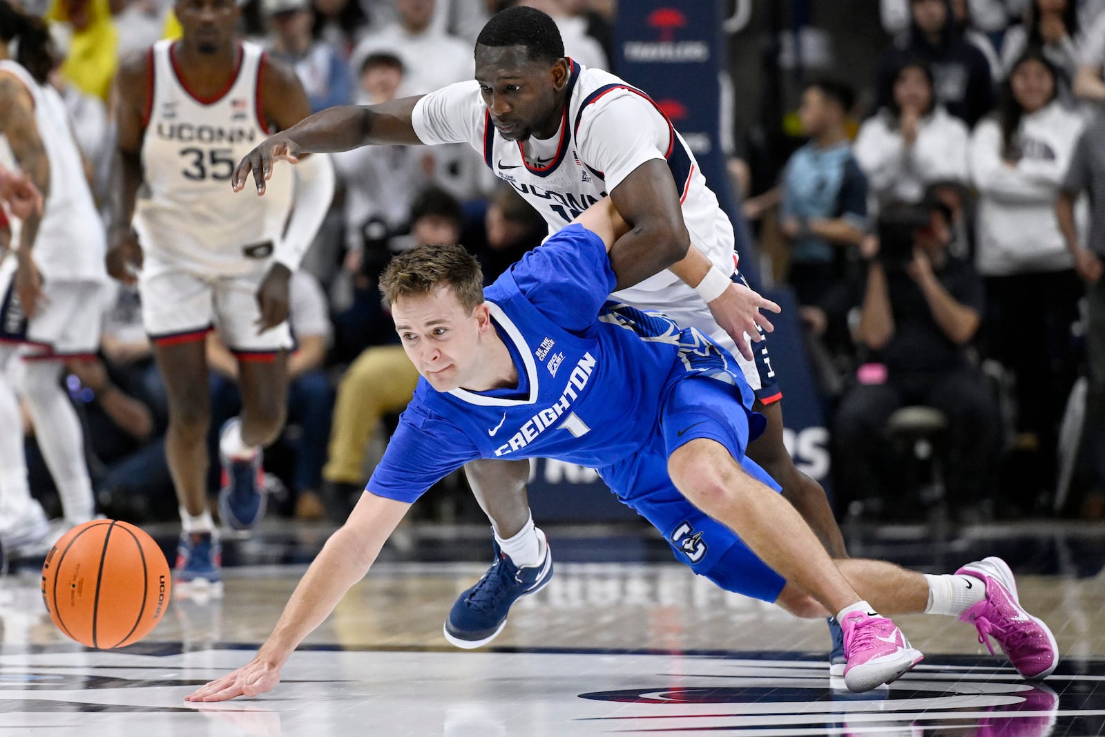 Creighton guard Steven Ashworth, bottom, and UConn guard Hassan Diarra chase after the ball in the second half of an NCAA college basketball game, Saturday, Jan. 18, 2025, in Storrs, Conn. (AP Photo/Jessica Hill)