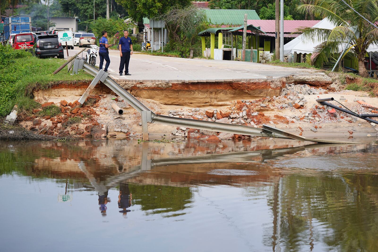 Men survey the damage caused by a flood in Tumpat, on the outskirts of Kota Bahru in Kelantan state on the east coast of Malaysia, Tuesday, Dec. 3, 2024. (AP Photo/Vincent Thian)