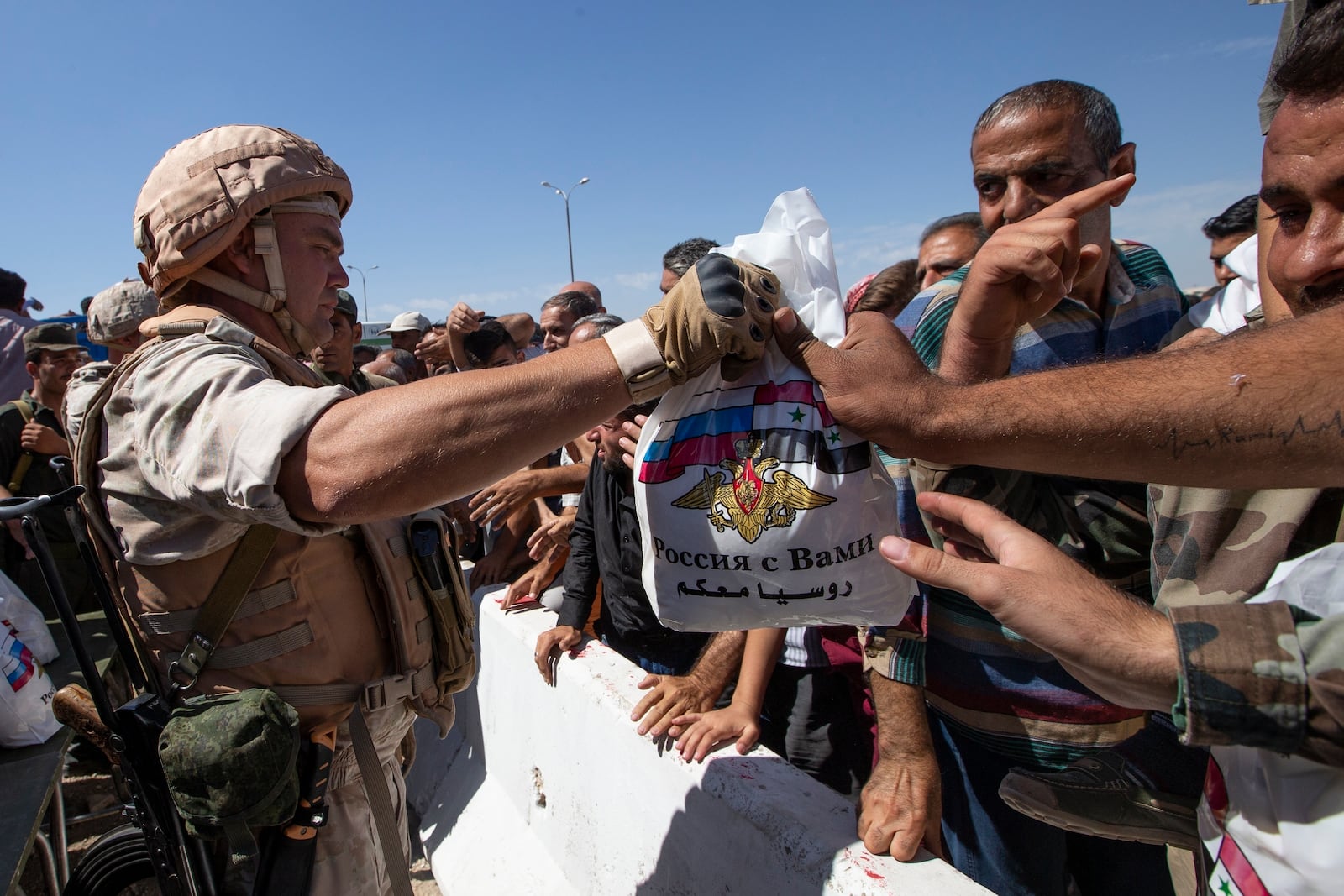 FILE - Russian soldiers distribute food and other supplies to residents in Khan Sheikhoun, Syria, on Sept. 25, 2019. (AP Photo/Alexander Zemlianichenko, File)