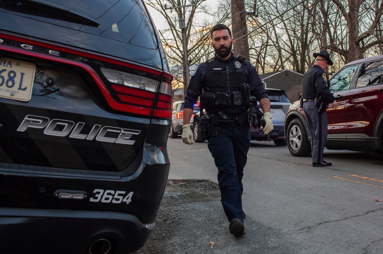 Officer Venereo Gomes with the Charlottesville Police Department holds evidence in his left hand as he walks back to his vehicle after Police catch and arrest the suspect in the stabbing at on the Grounds of the University of Virginia on Thursday, Feb. 27, 2025. (Cal Cary/The Daily Progress via AP)