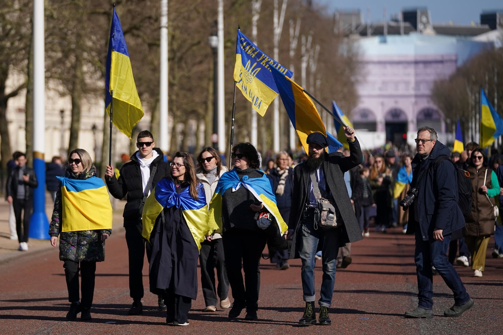 Ukrainian supporters waving flags and banners walk down the Mall as Britain's Prime Minister Keir Starmer chairs a Ukraine Summit at Lancaster House in London, Sunday, March 2, 2025. (AP Photo/Alberto Pezzali)