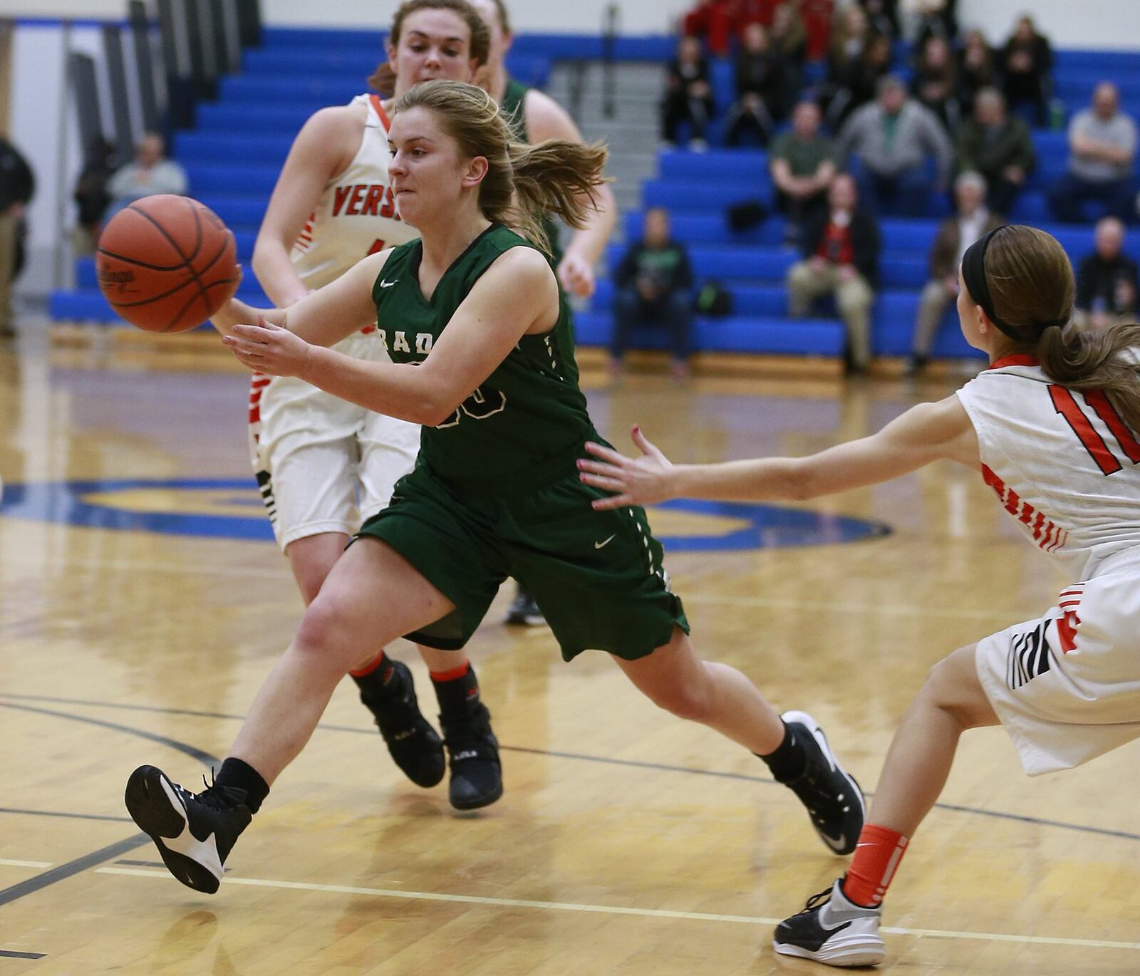 Badin’s Macy Harper gets past Versailles’ Camille Watren (11) and makes a pass during Wednesday night’s Division III regional semifinal at Springfield. BILL LACKEY/STAFF