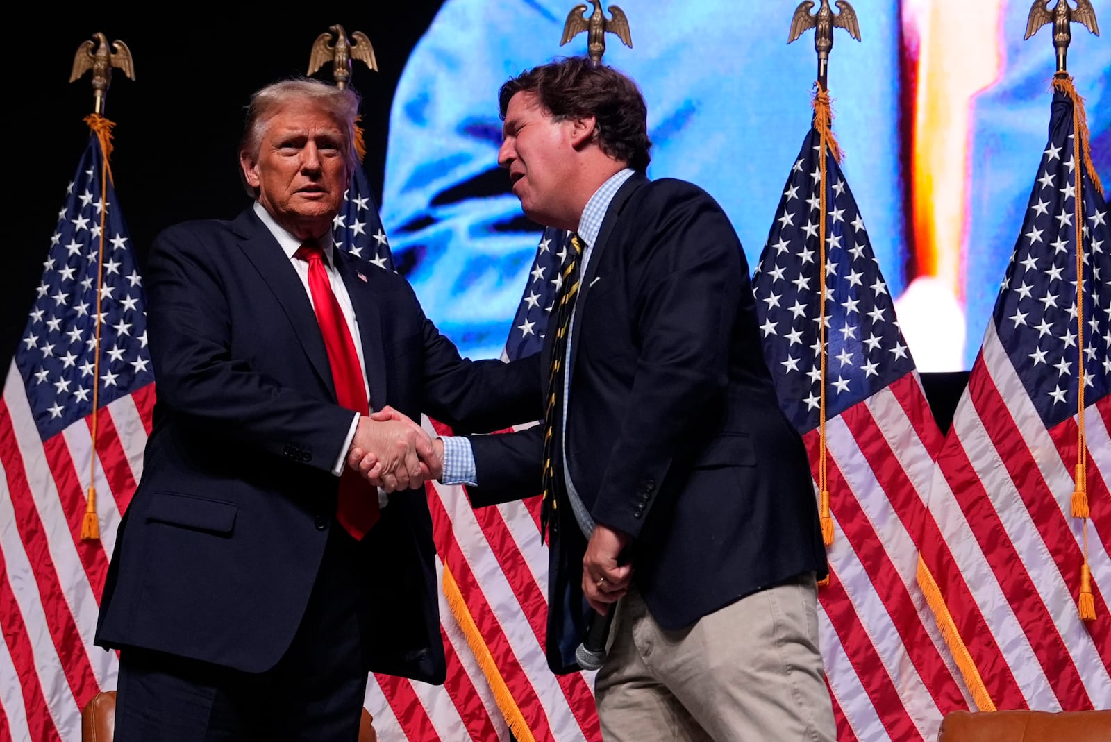 Republican presidential nominee former President Donald Trump speaks with Tucker Carlson during a Tucker Carlson Live Tour show at Desert Diamond Arena, Thursday, Oct. 31, 2024, in Glendale, Ariz. (AP Photo/Julia Demaree Nikhinson)