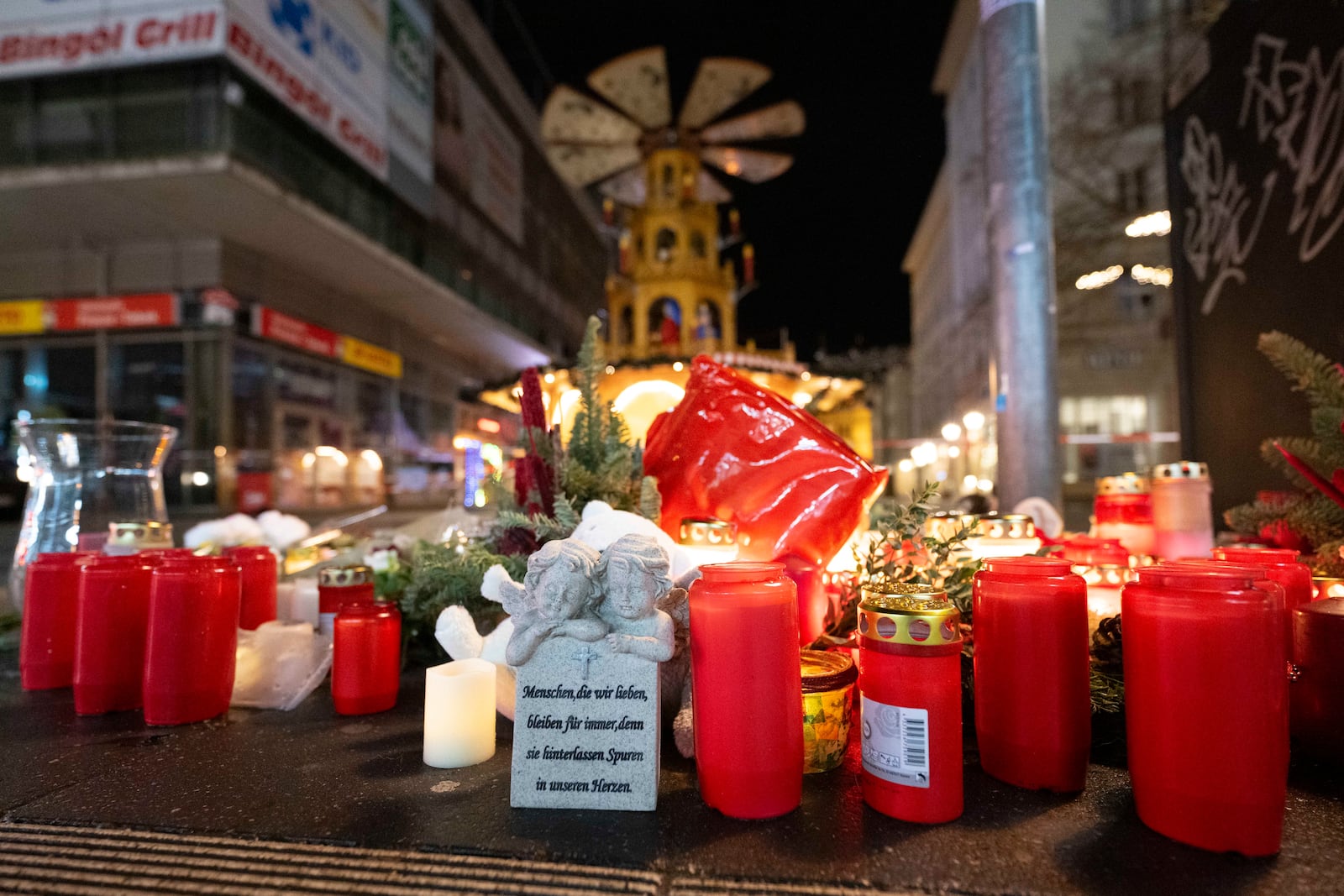 Candles sit in front of the Christmas market early Sunday, Dec. 22, 2024, in Magdeburg, Germany, after a car drove into a crowd at the market on Friday, Dec. 19. (Sebastian Kahnert/dpa via AP)